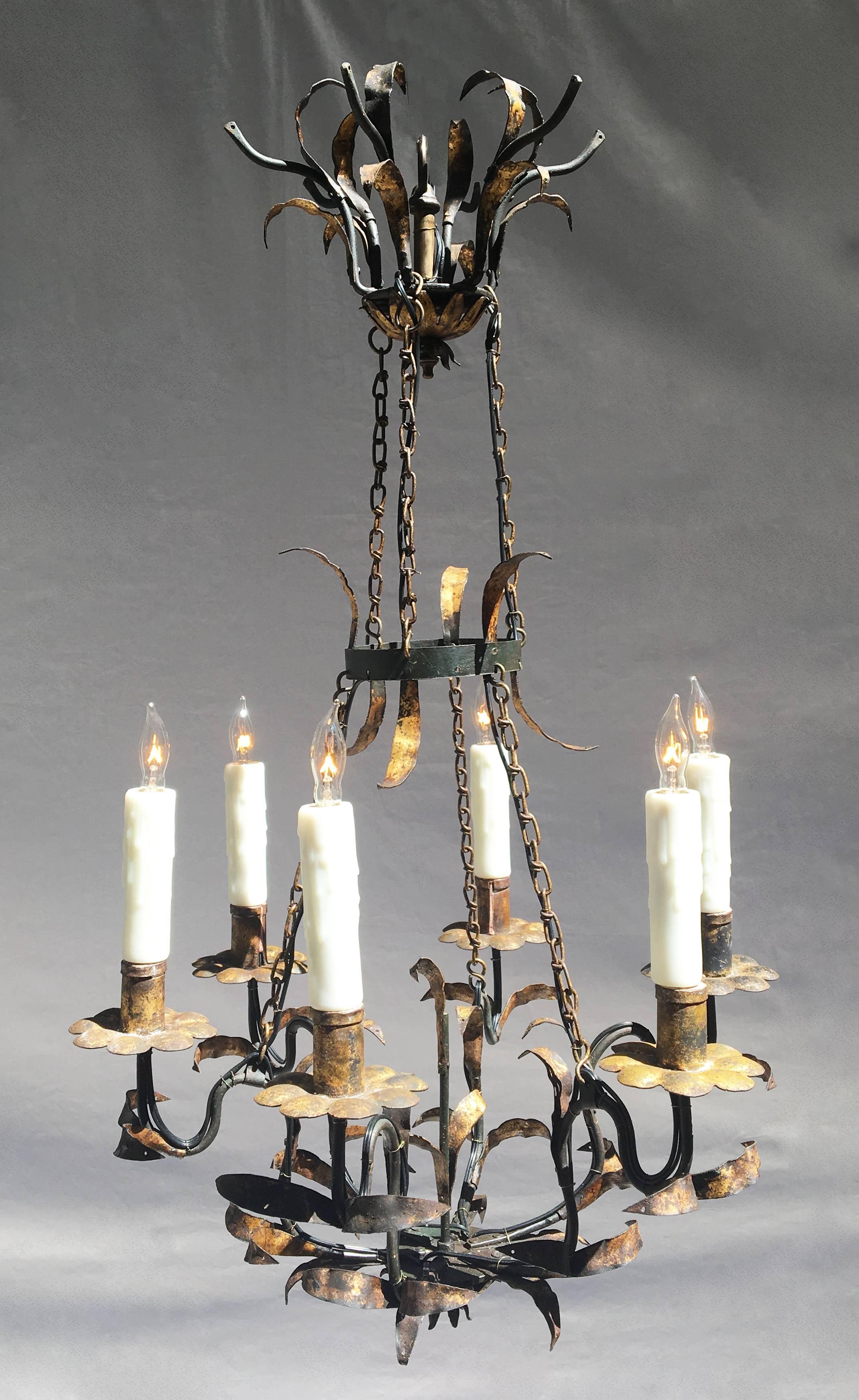 This early 19th century Italian wrought iron chandelier is decorated with gilded tole leafs. Originally candle, this six arm chandelier has been rewired and electrified. 

Comes with matching chain and canopy.
