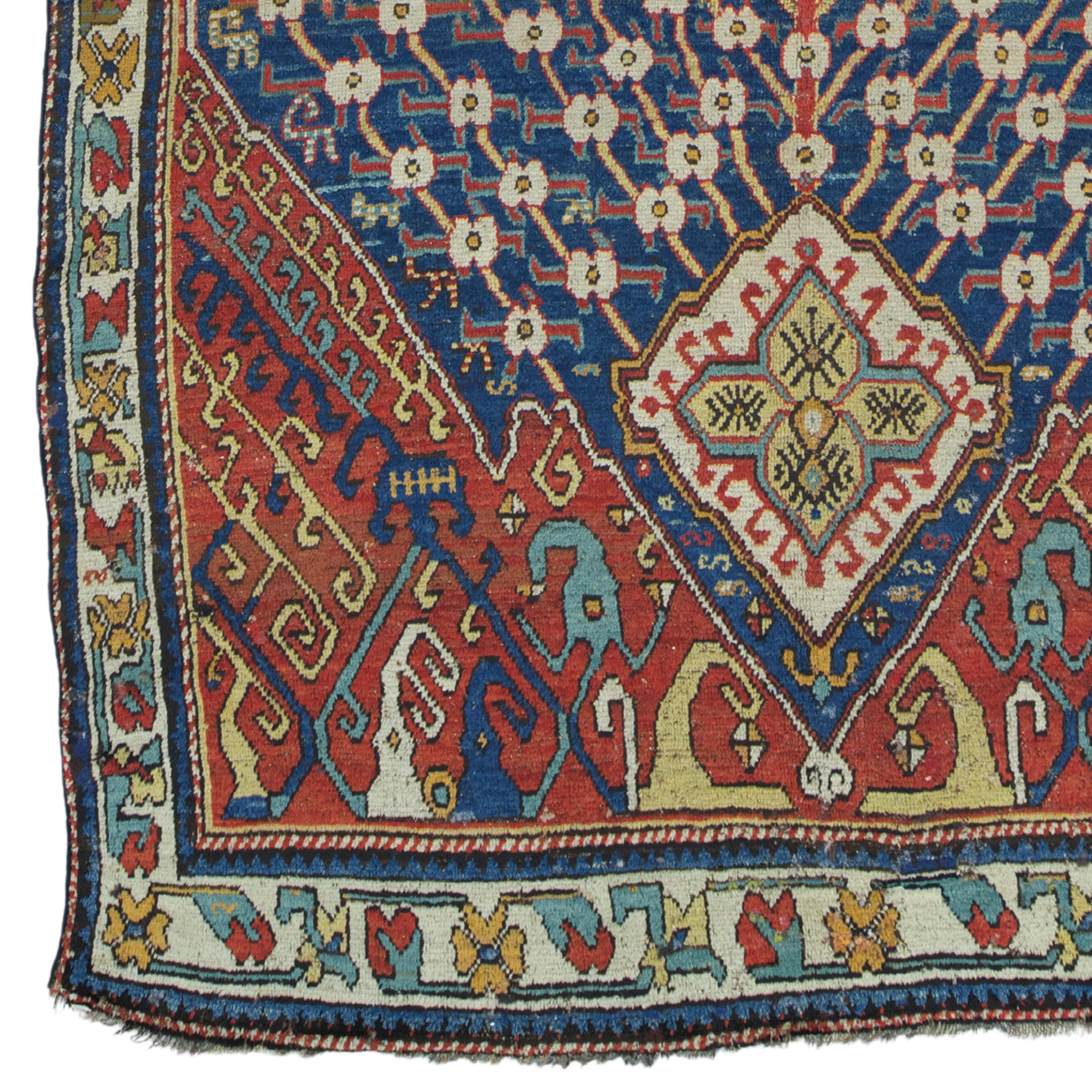This elegant mid-19th-century Caucasian rug has a rich and intricate design, featuring geometric patterns and stylized floral motifs surrounded by a central medallion in shades of gold, red, and blue. The border decorations are detailed with smaller