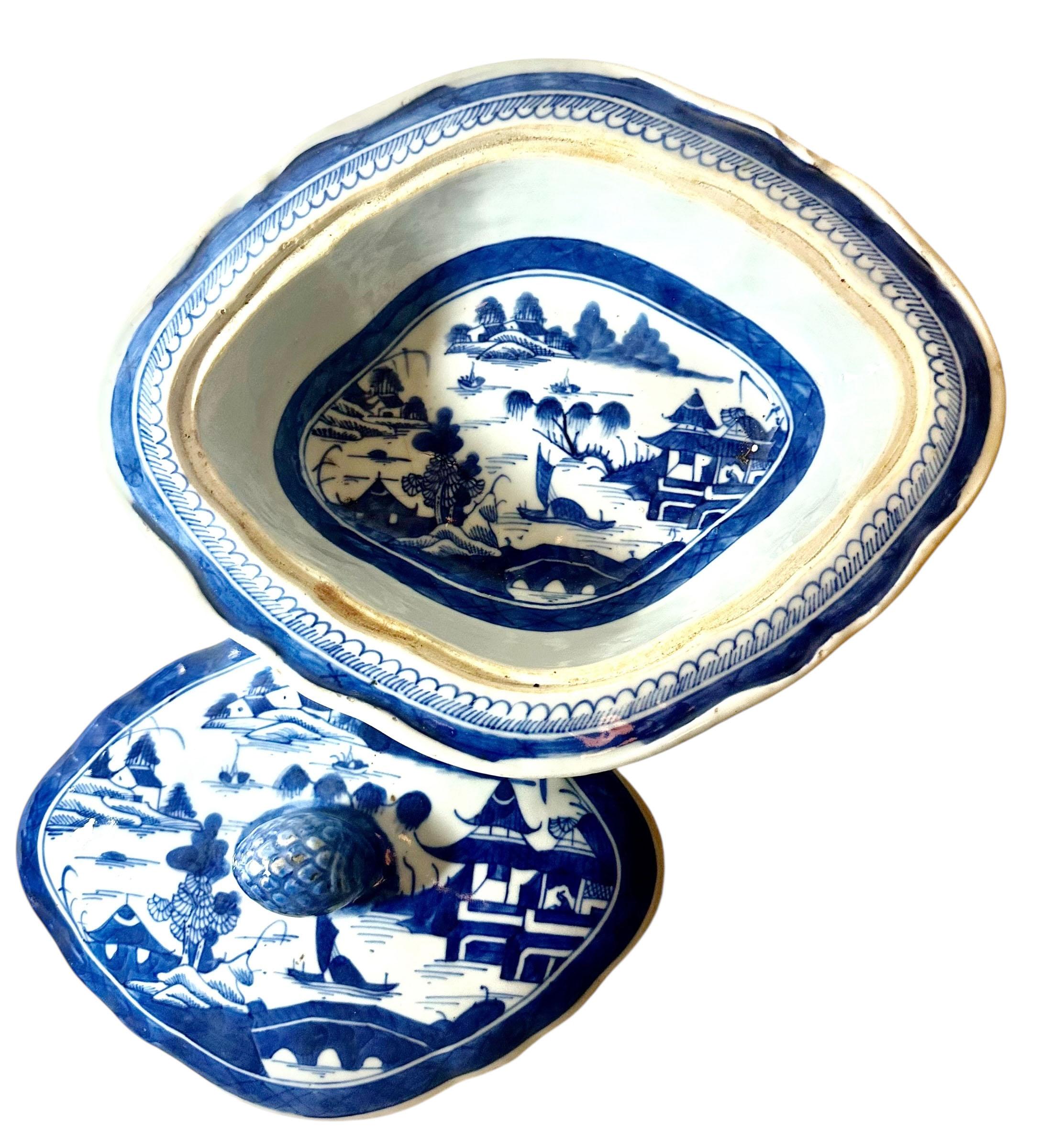Grand plat couvert en porcelaine de Canton bleue et blanche, richement peint à la main d'une scène de village élaborée au bord de l'eau. Le couvercle est orné d'un magnifique fleuron en forme de gland et est très décoré à l'intérieur et à