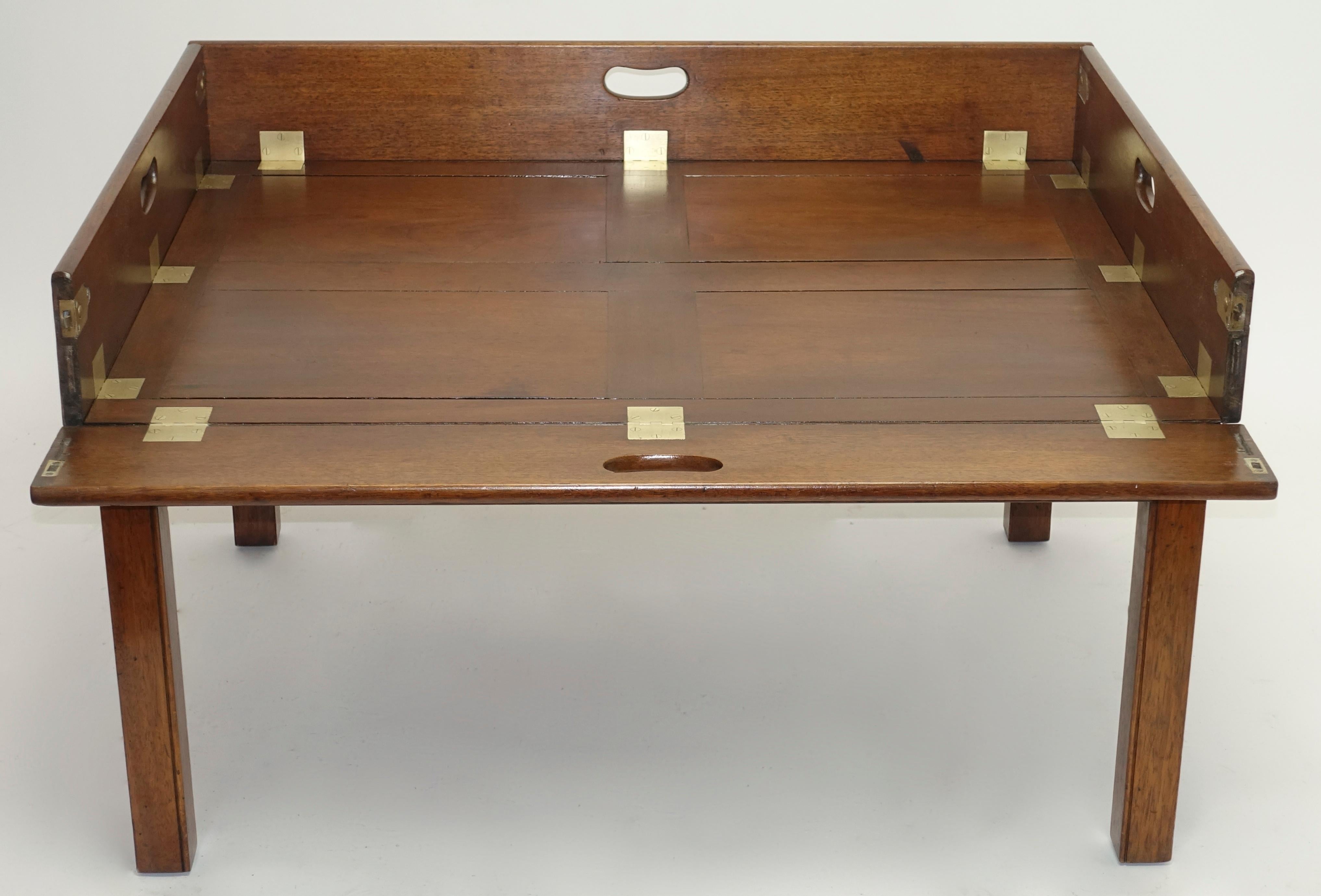 Unusually large and beautiful English Georgian mahogany butlers tray with drop sides with brass hinges and clasps
rests on a later custom made early 20th century coffee table height mahogany stand
Tray, circa 1810-1840.


 