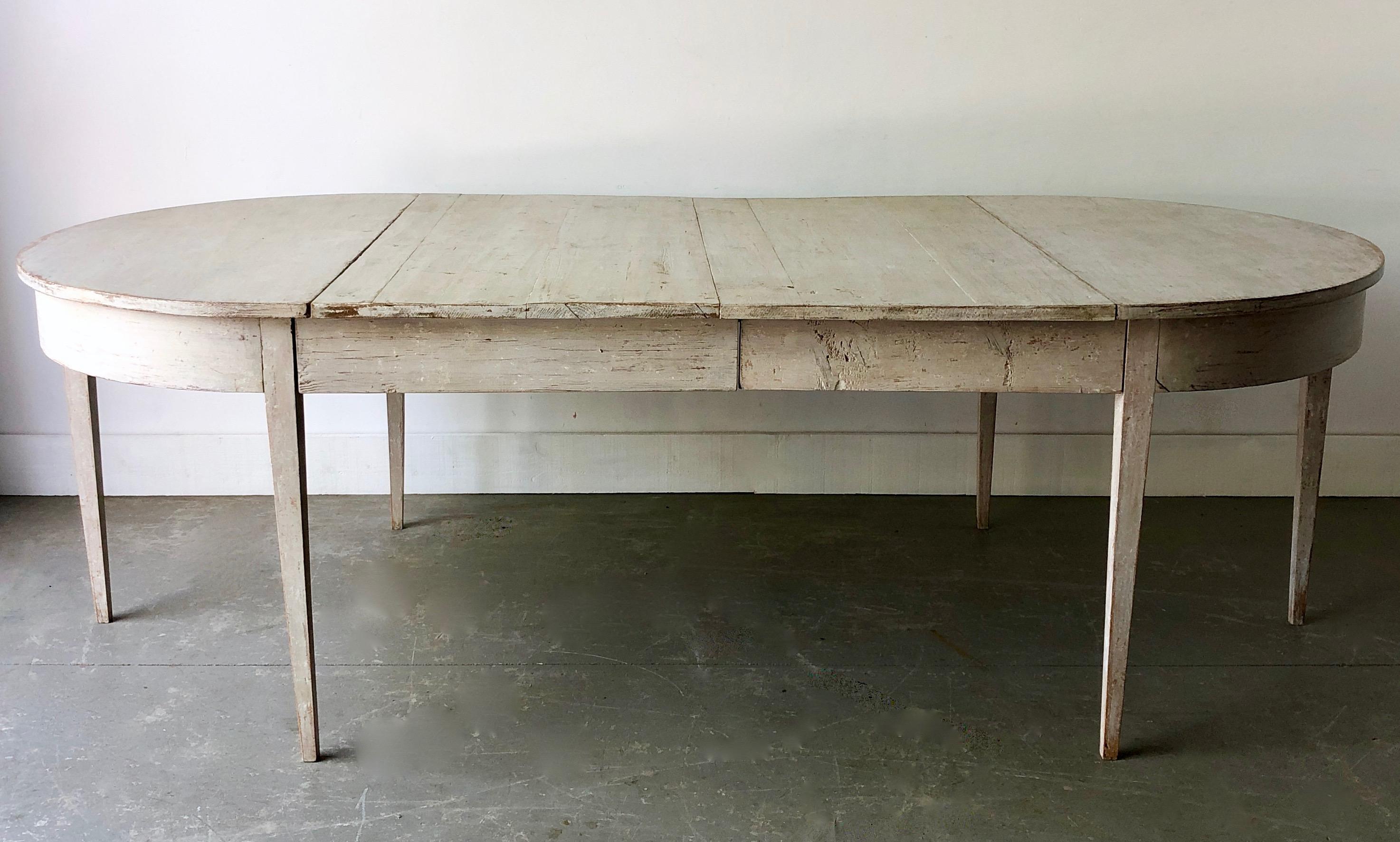 Early 19th century later painted Gustavian period extending table with two leaves and tapered legs. A practical piece that can be used as round table/ a pair of consoles or extended with one or two leaves up to 93