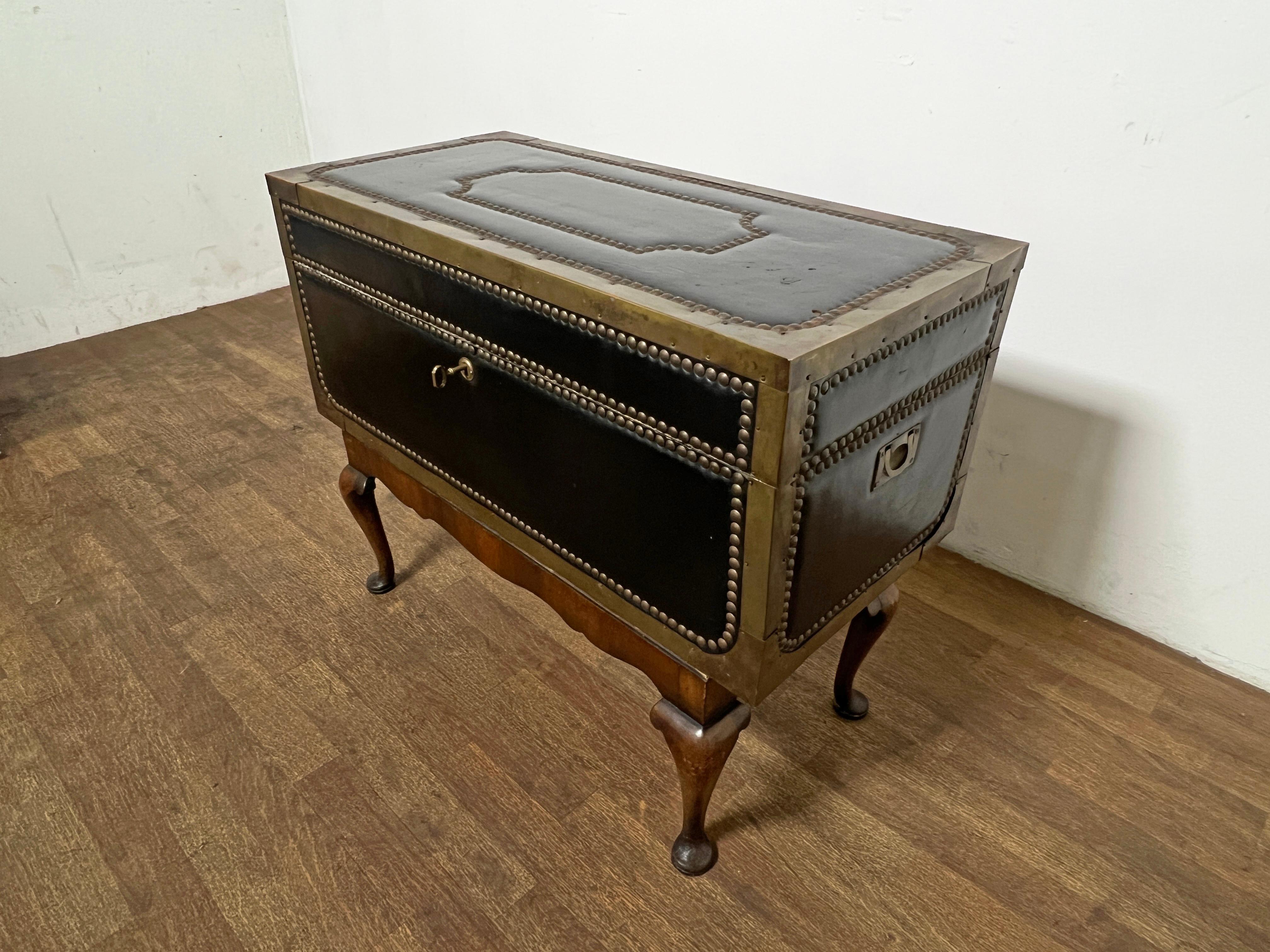 Leather bound camphor wood trunk on mahogany stand with cabriole legs, as found; chest featuring nailhead trim and brass binding. Working key included.

Trunk measures 31 3/8