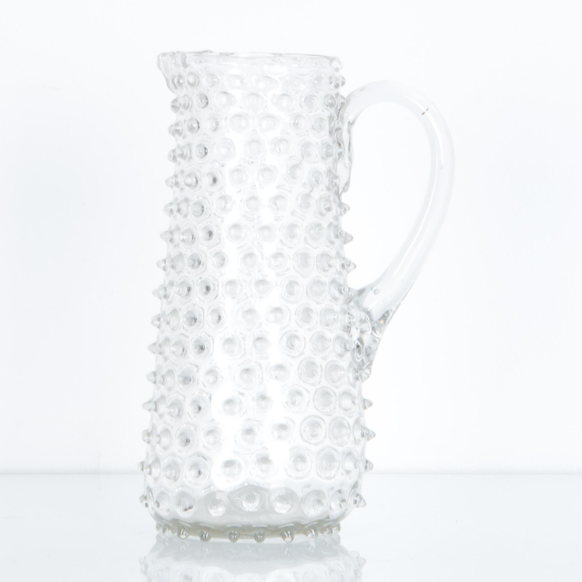 A decorative 11” pitcher from Belgium, circa 1800. A distinctive regional style from Liege glass factories of the period. Exquisitely crafted by traditional glassblowers, the textured surfaced is dotted with raised bumps of glass, a graphic network