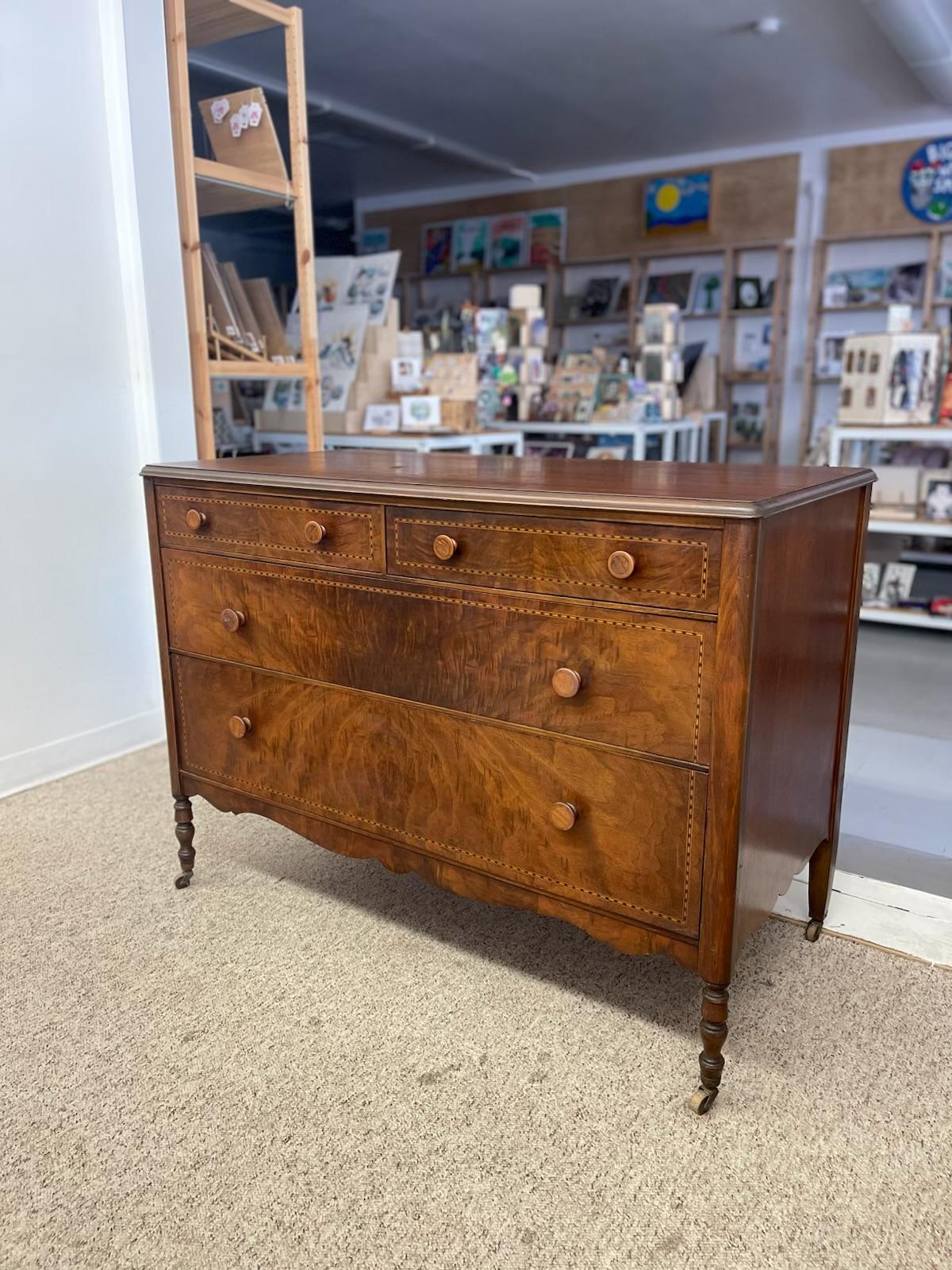   This finely crafted chest of drawers, stamped 1817, is an exceptional example of early American craftsmanship.
Made from what is possibly solid mahogany with matched burl drawer fronts, the dresser features intricate diamond-patterned wood inlay