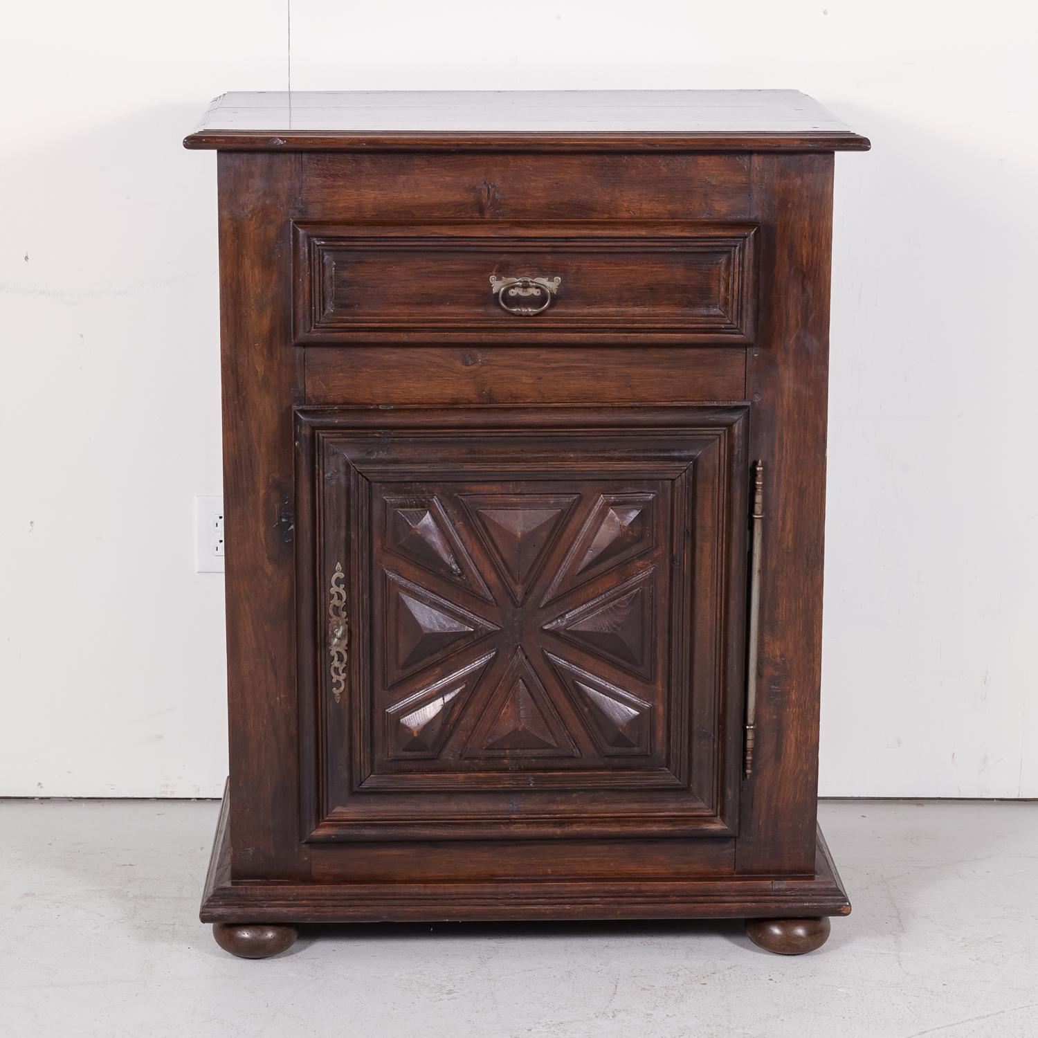 A tall early 19th century French Louis XIII style jam cabinet or confiturier from Normandy, circa 1820s. Handcrafted of old growth oak with a rectangular beveled edge top over a single full-width drawer defined by bold molding and having a raised