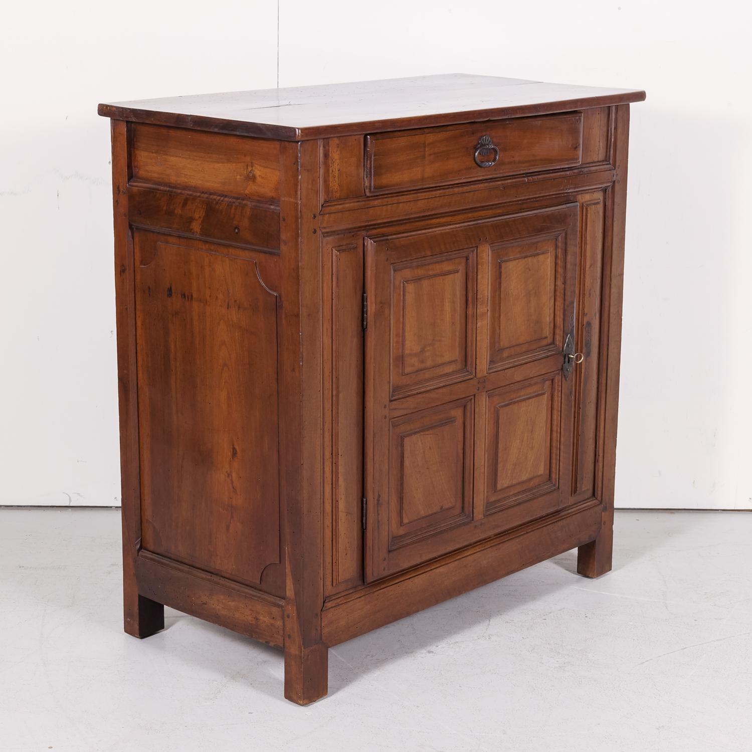 Early 19th century French Louis XIII style cabinet de confiture or jam cabinet handcrafted in Normandy of solid walnut with a rectangular top over a single drawer above a door having four raised panels that opens to reveal a single shelf, circa