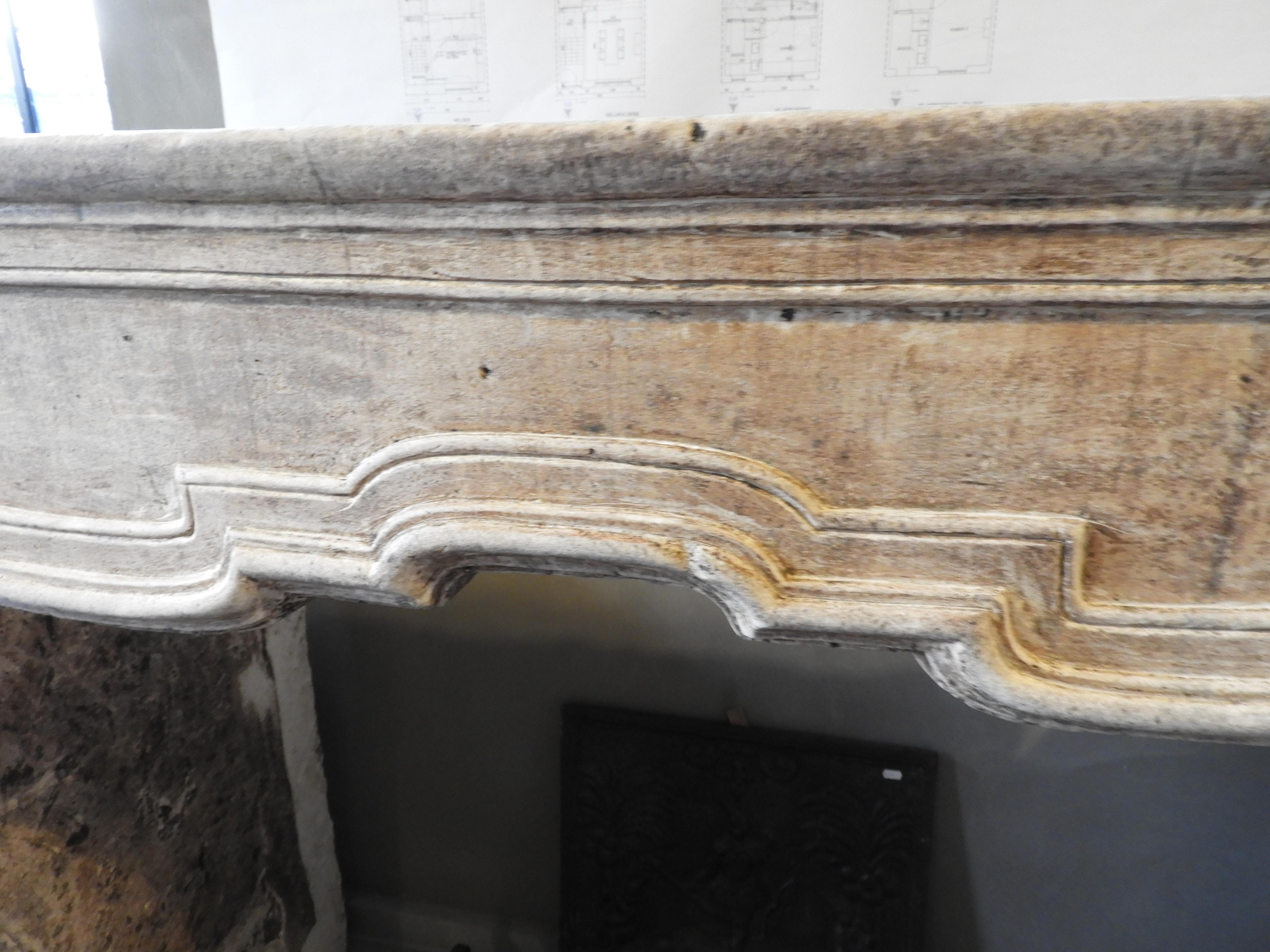 Early 19th century limestone fireplace, white/beige of color in its original patina.