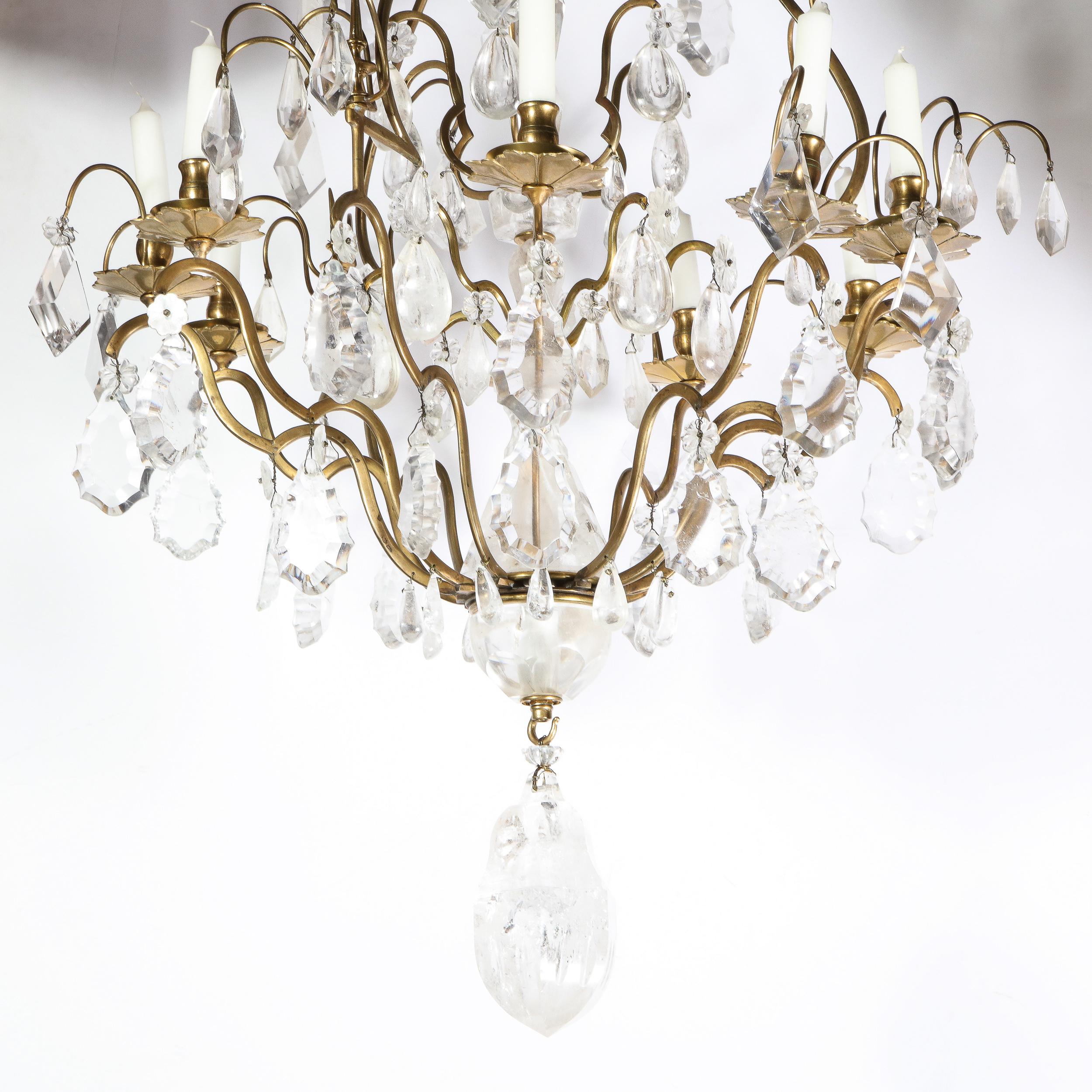 This elegant rock crystal and gilded bronze nine-arm chandelier was realized in France, during the early 19th century. It features a central baluster body carved in rock crystal from which nine sinuously curved gilded bronze arms extend culminating