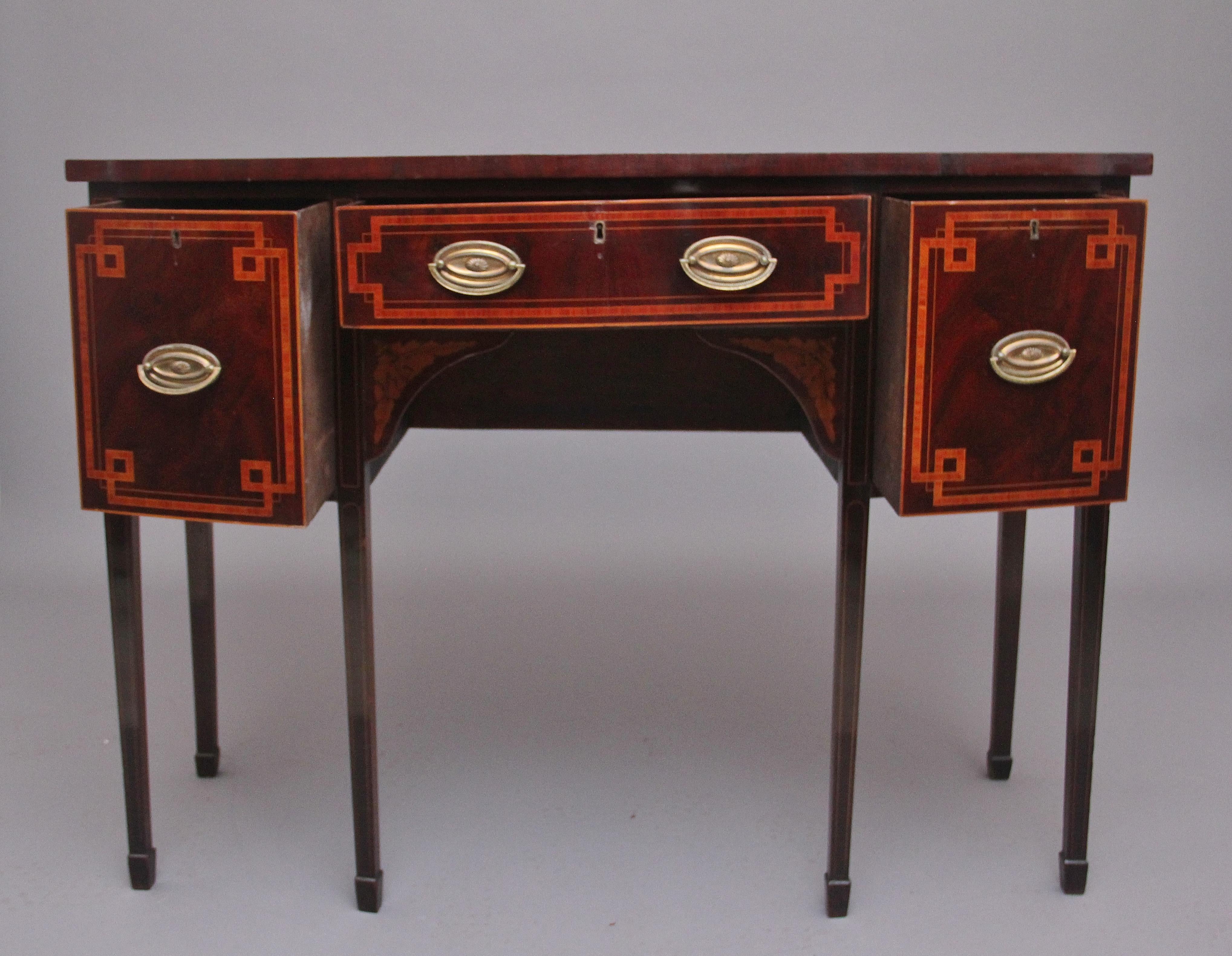 Early 19th century mahogany and inlaid sideboard, having a shaped and crossbanded top above three oak lined drawer with oval brass handles, the drawer fronts having decorative inlay, the shaped central frieze below with floral inlay, supported on