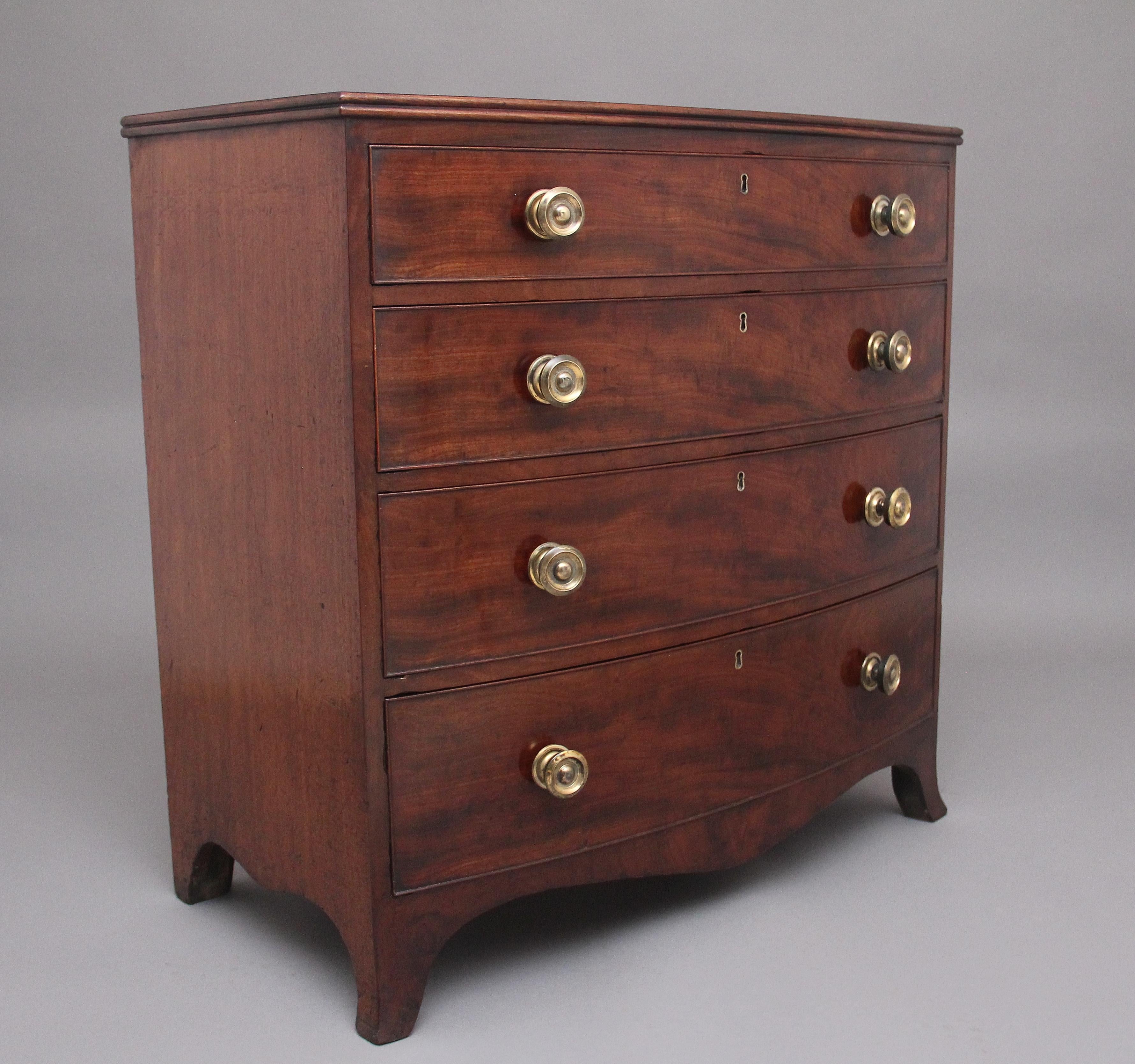 Early 19th Century mahogany bowfront chest of drawers of nice proportions, having a lovely figured top above four graduated oak lined drawers with the original turned brass handles, shaped apron and supported on splay feet.  Circa 1800.
