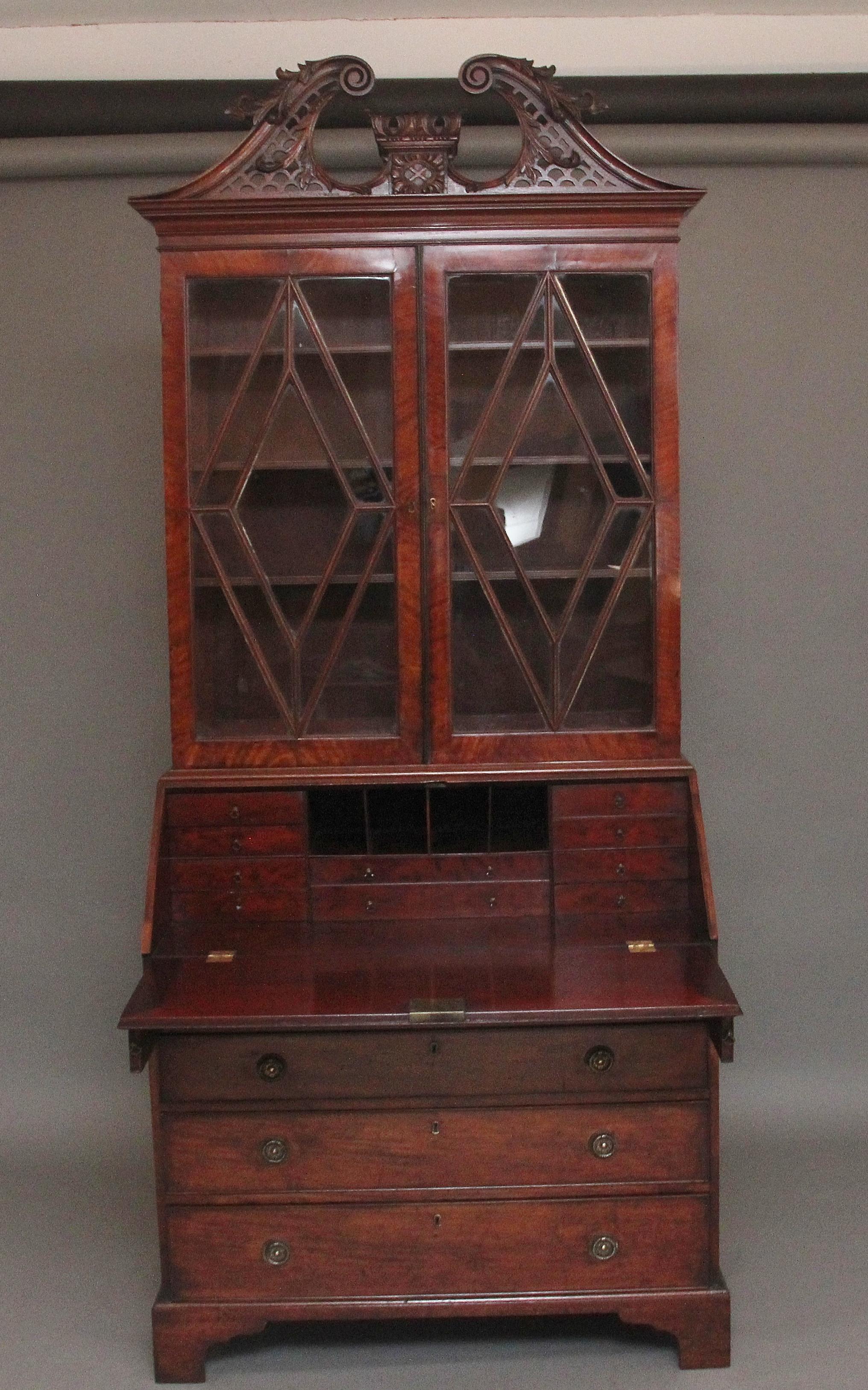 A lovely quality early 19th Century mahogany bureau bookcase with later (Edwardian) cornice, the highly decorative carved pierced fret swan neck pediment with a central box column with further carved floral decoration, the top section having two