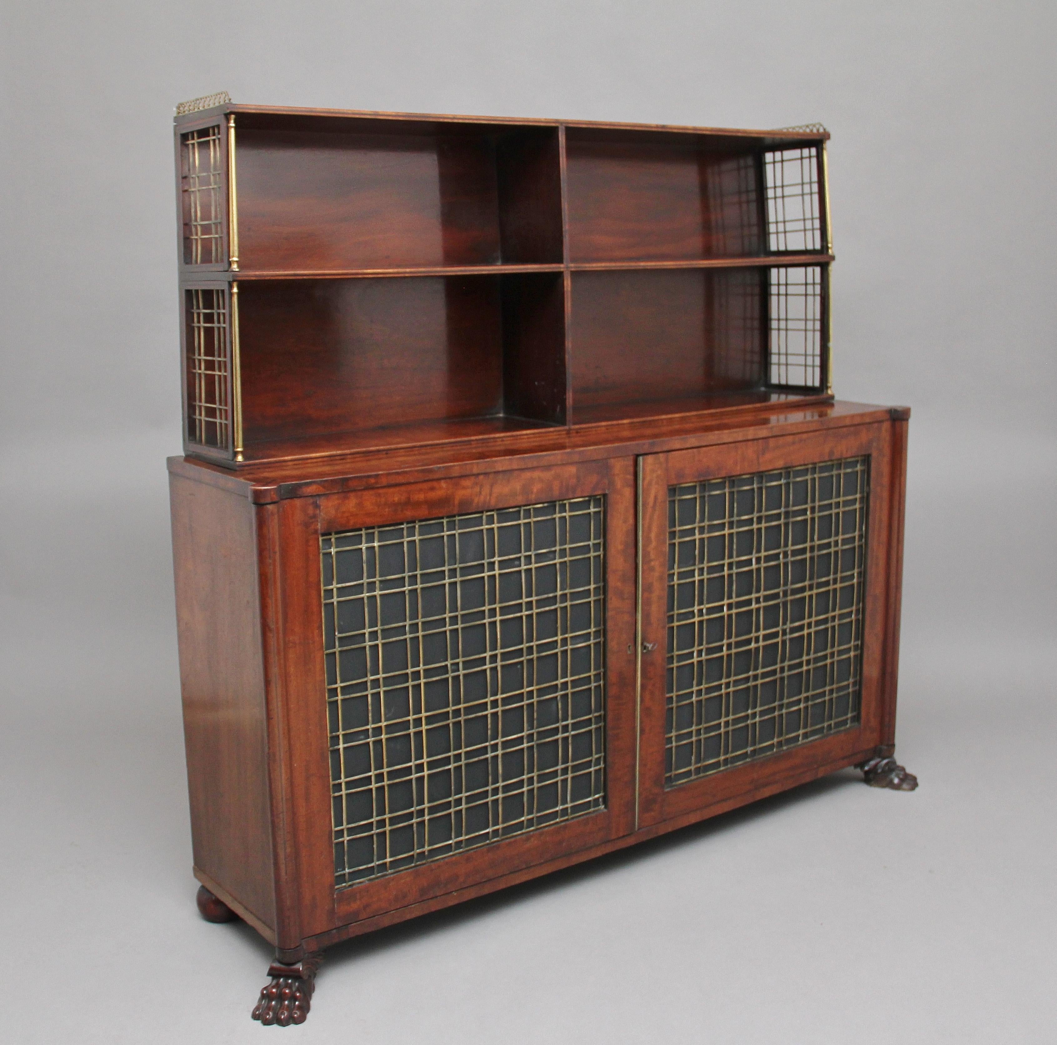 A lovely quality early 19th century mahogany cabinet of good proportions, having a decorative brass pierced gallery running along the top, the top shelf section divided into four compartments with ebony inlay on the shelve fronts and having brass