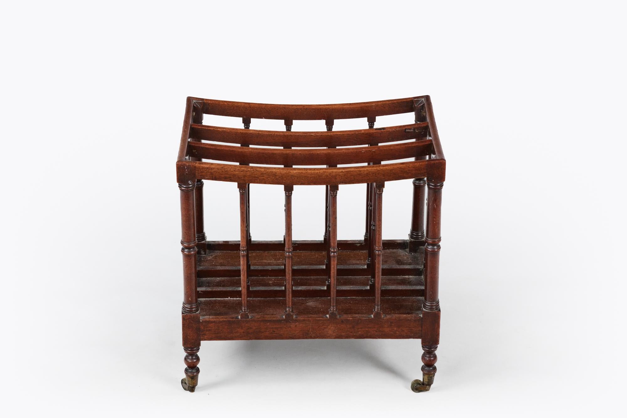 Early 19th century mahogany Canterbury, three slatted divisions over a single beaded drawer and raised on slender turned legs and brass castors, circa 1820.