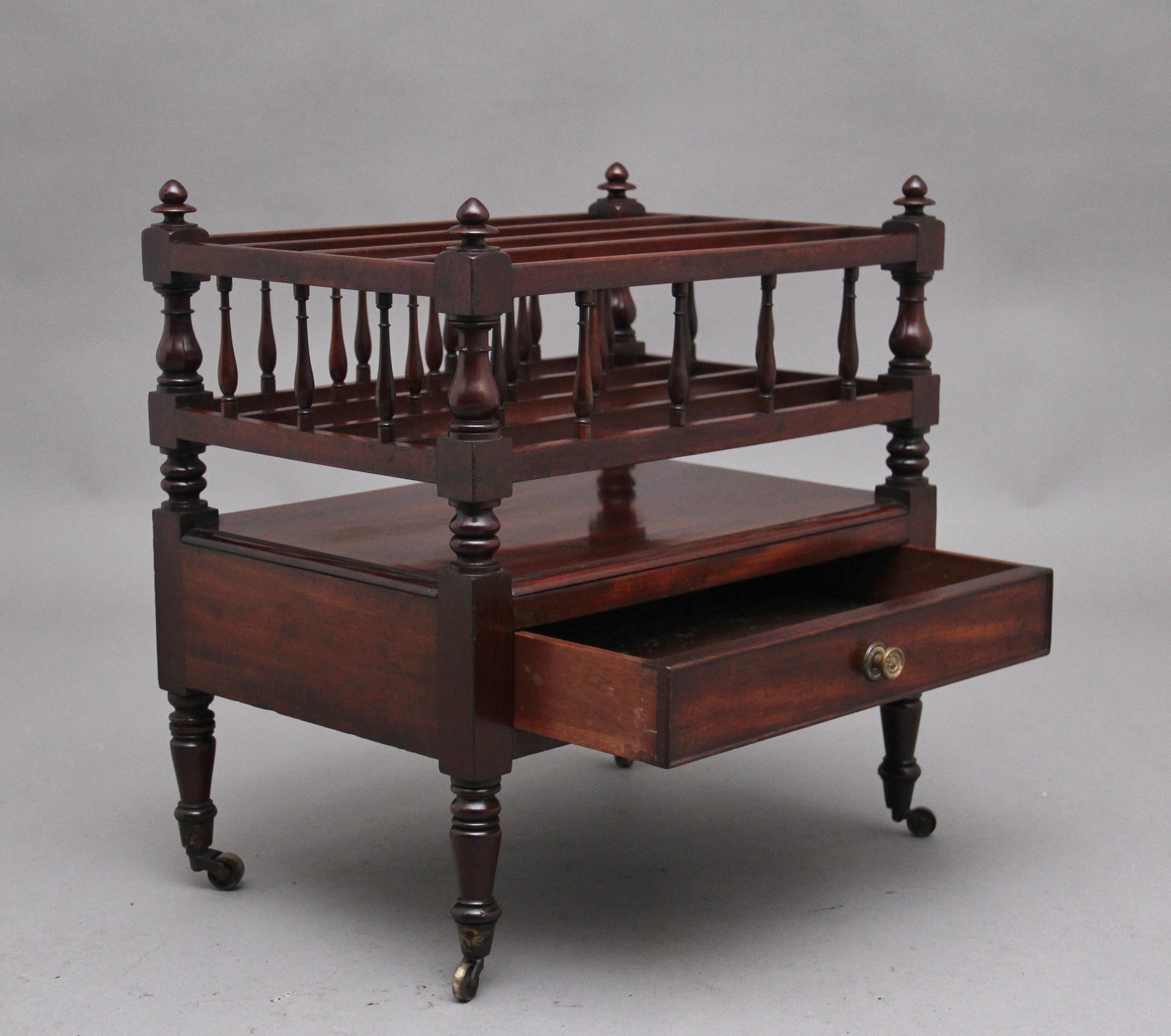 Early 19th Century mahogany Canterbury, the top section having turned columns in each corner finished with turned finials, inside having four dividers incorporating fine turned columns, having a mahogany lined frieze drawer below with original brass