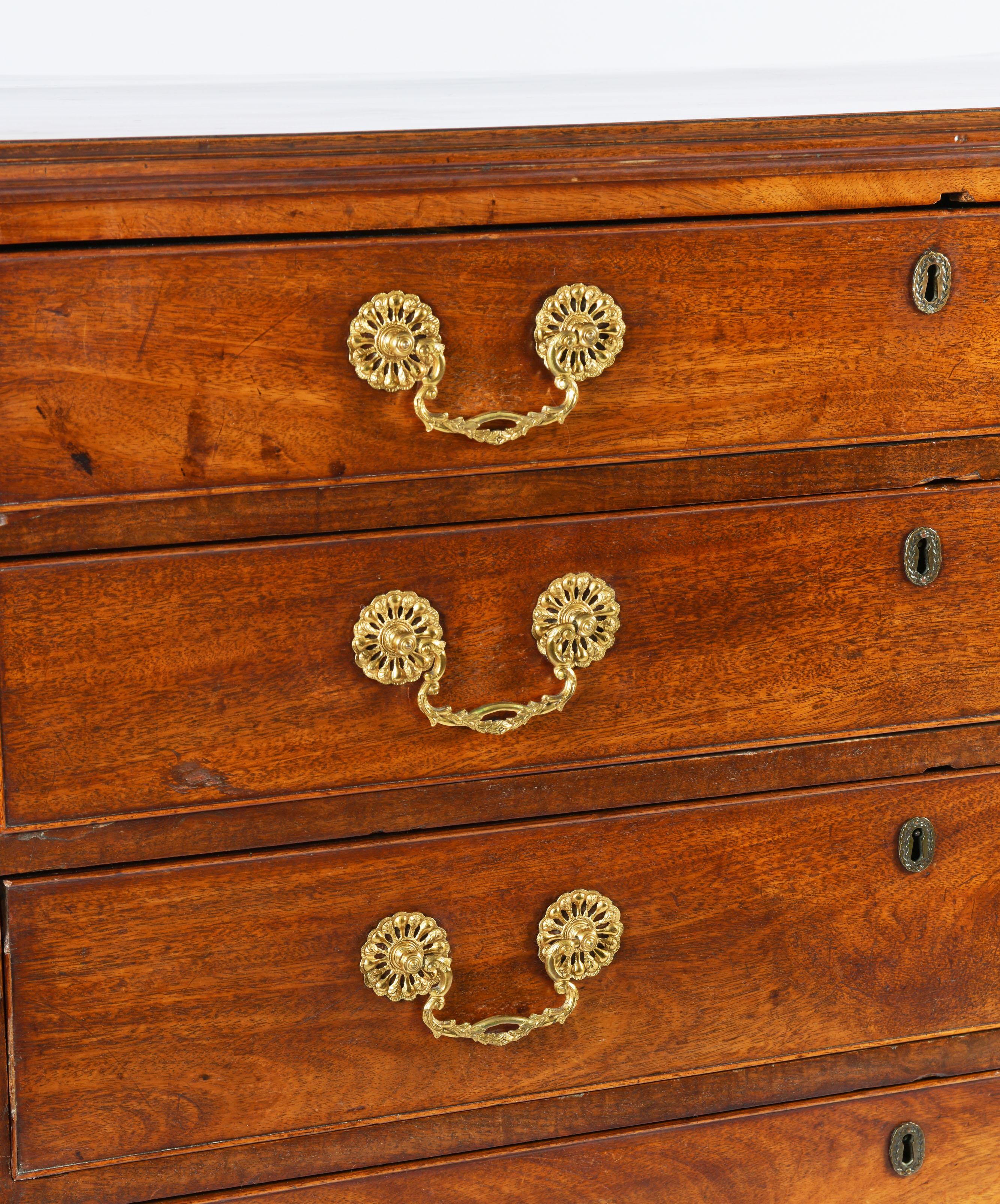 This very attractive and well-proportioned mahogany chest of drawers features 5 long graduating cock beaded drawers with the original ornate brass handles and hardware, supported on bracket feet. It measures 40 in – 101.6 cm wide, 21 ½ in – 54.6 cm