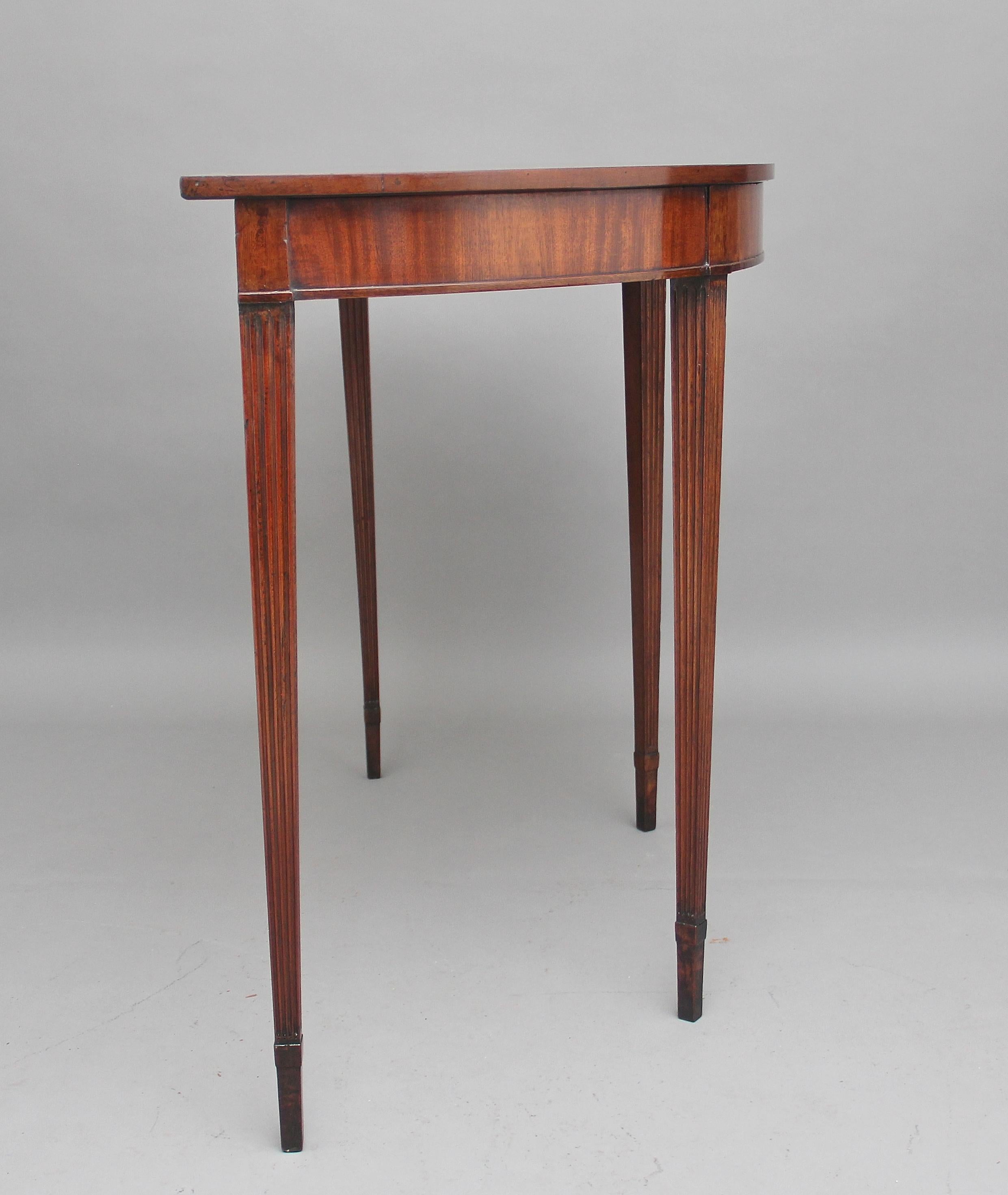 An early 19th century mahogany console table, the demilune shaped top above a nice deep frieze, supported on fluted square tapering legs, circa 1820.