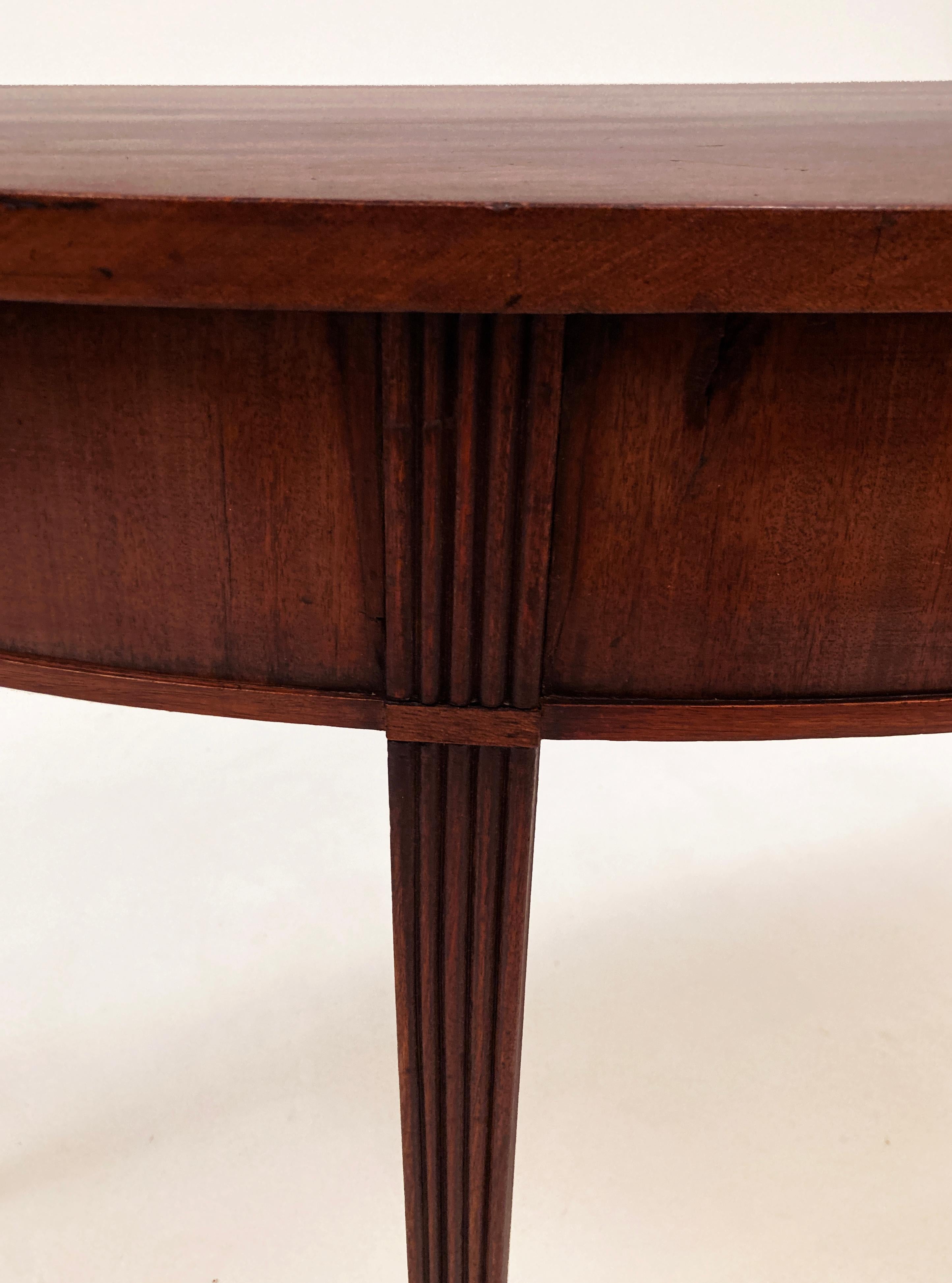 This lovely early 19th century, English mahogany demi-lune table came from the estate of a prominent southern family in Louisville, Kentucky. This table is estimated to have been built in the early 1800's. The beautiful figured top of this Georgian