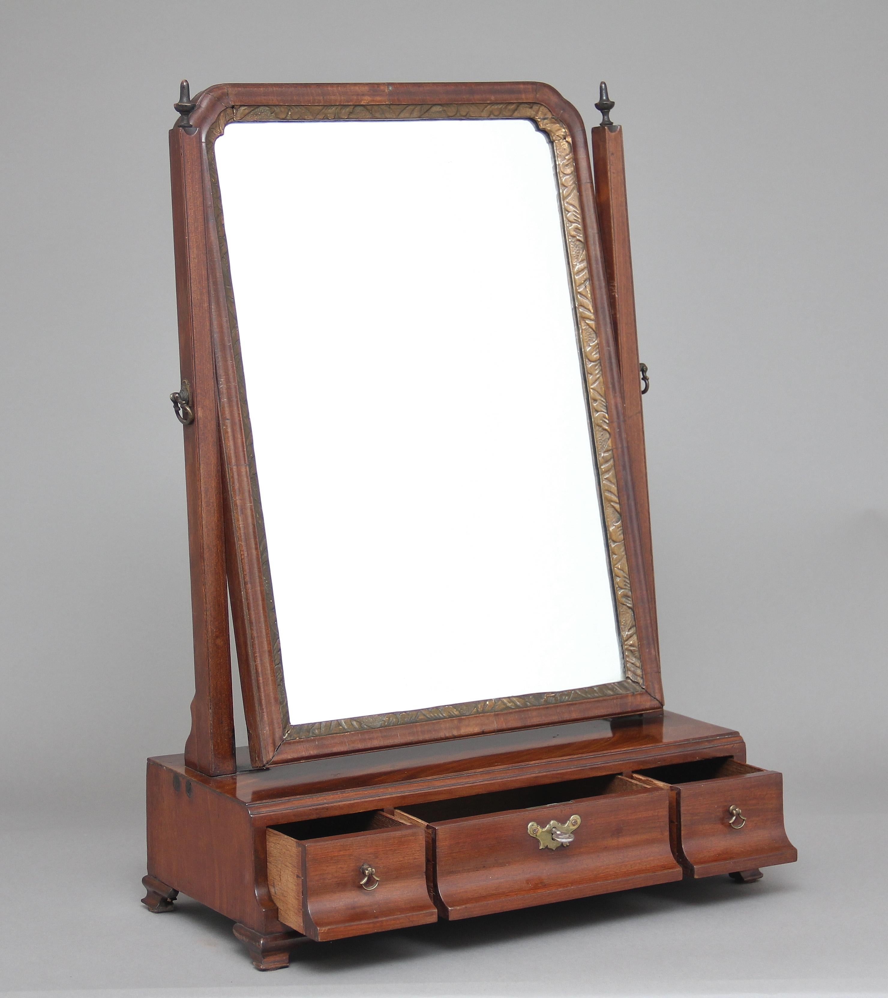 Early 19th century mahogany dressing table / toilet mirror, with a swivel mirror, the frame decorated with wooden finials on top, the base section having three oak lined drawers, standing on small ogee feet, circa 1800.
 