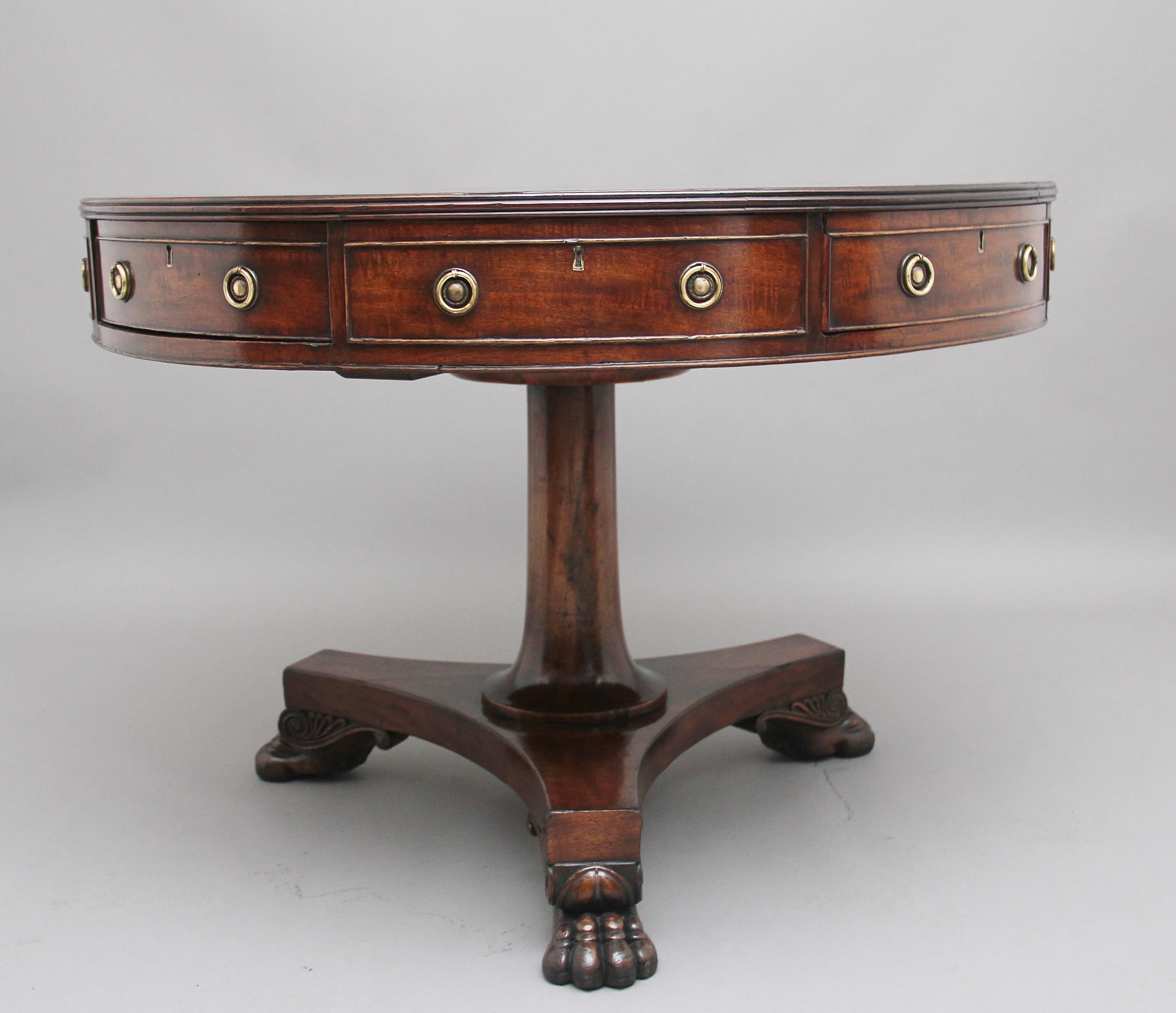 Early 19th Century mahogany drum table, having a green leather leather top decorated with blind and gold tooling and crossbanded in mahogany around the edge, the frieze below having a combination of four working drawers and four faux drawers, all