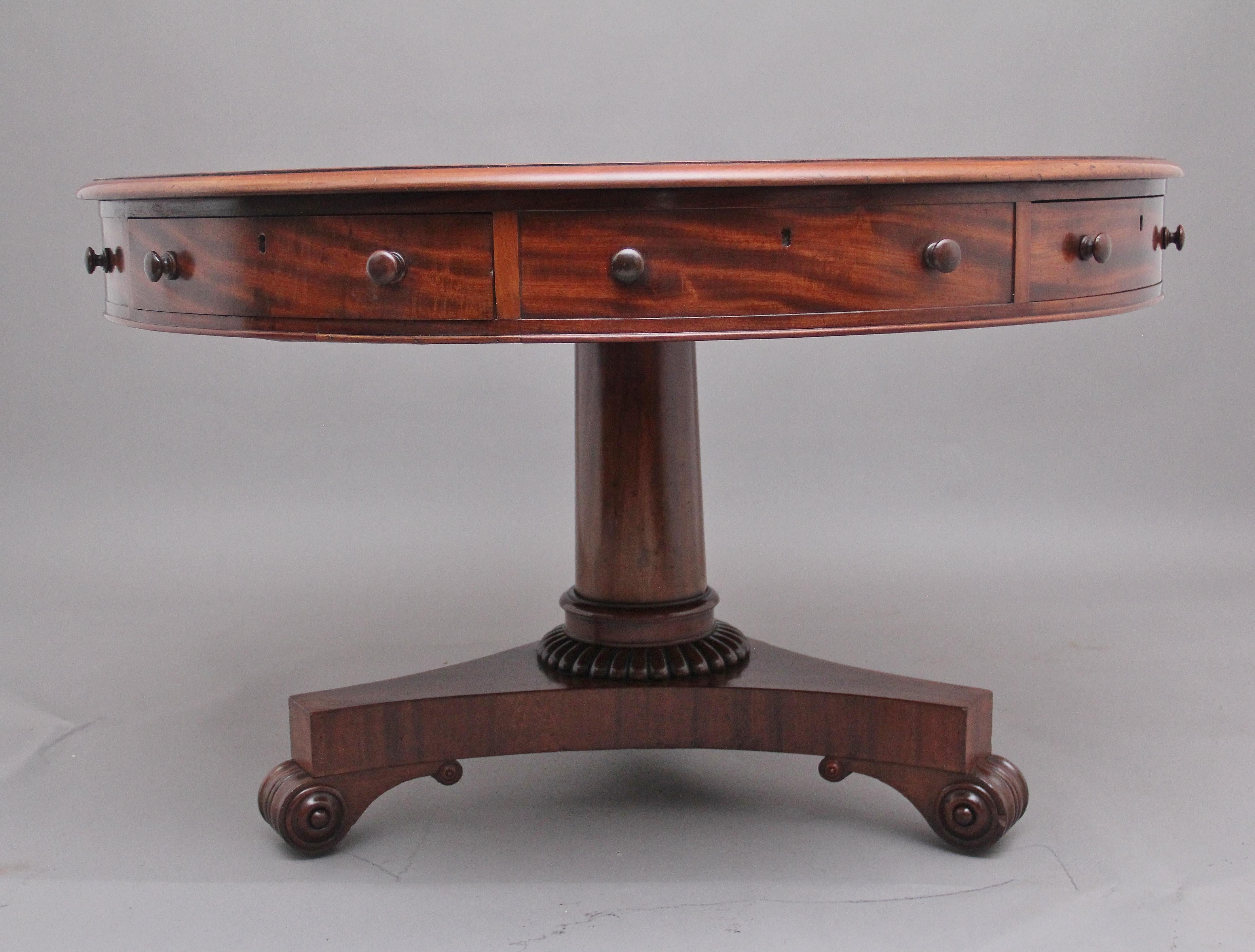 Early 19th Century mahogany drum table, having a lovely figured moulded edge top above a frieze with a combination of four working mahogany lined drawers and four faux draws, with the original wooden turned knob handles, supported on an elegant