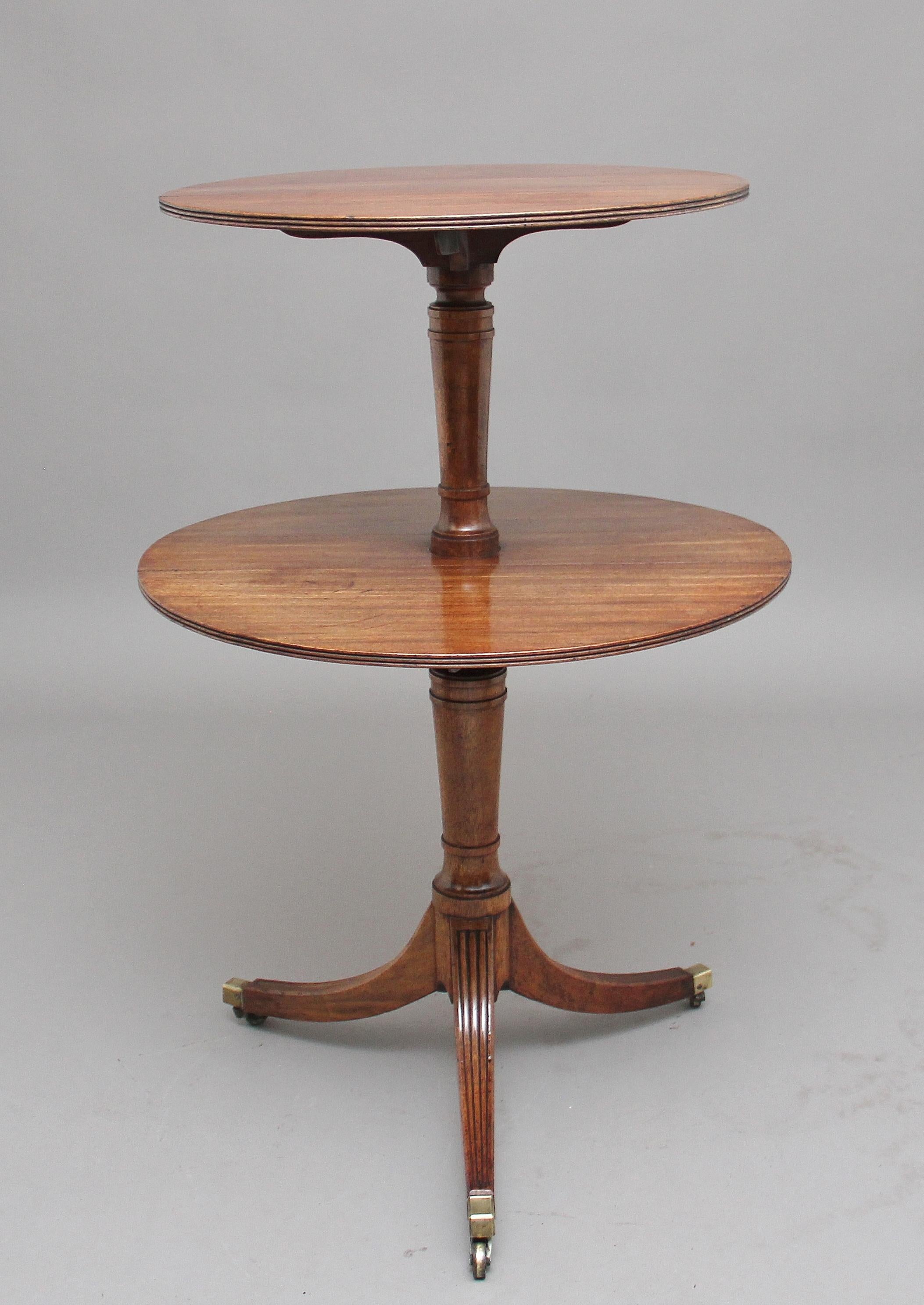 A rare and unusual Regency mahogany double drop leaf dumbwaiter, a smaller drop leaf above the larger opening up of circular form with a reeded edge, tapered columns supports with three reeded splayed legs terminating on brass cap and castors, circa