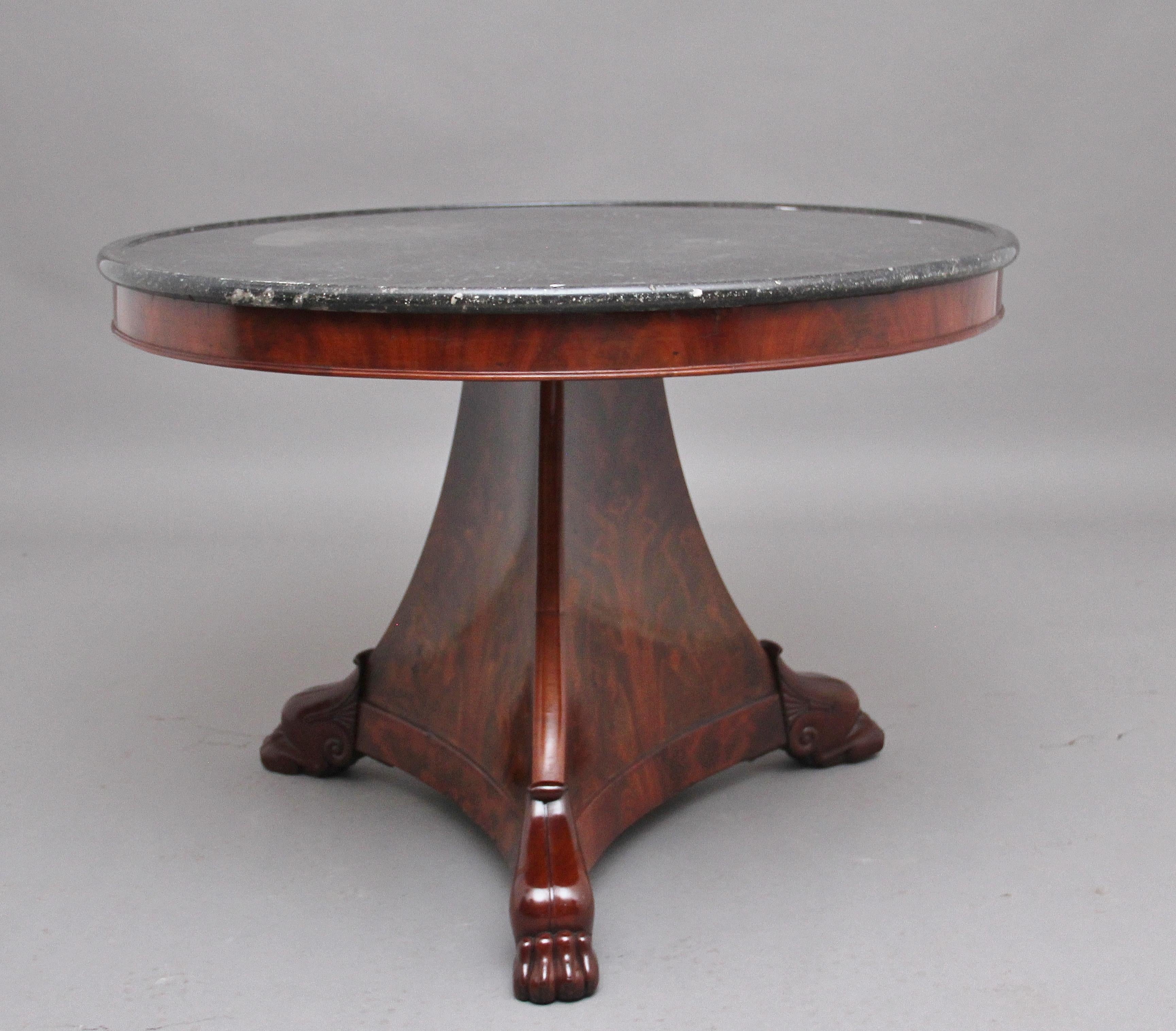 Early 19th century mahogany French gueridon / center table with a grey marble top with a moulded edge, nice figured frieze below with a beaded edge, shaped tri-form base supported on crisp carved claw feet. Circa 1820.