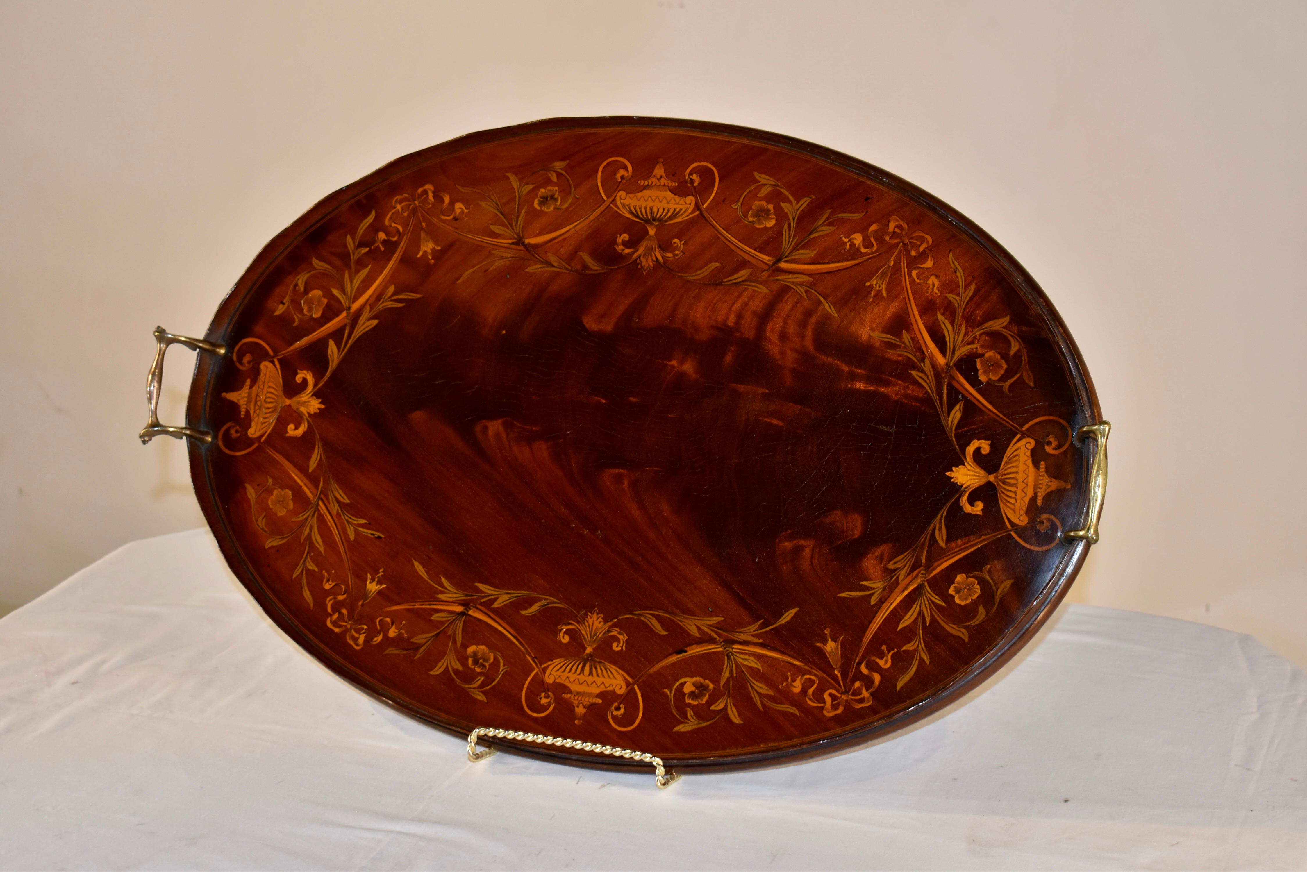 Early 19th century mahogany tray from England inlaid in a lovely pattern with florals and vines. On each side, there are symmetrical inlaid urns as well, and the floral swags and vines are in differing colors of dyed boxwood.  The tray has a hand