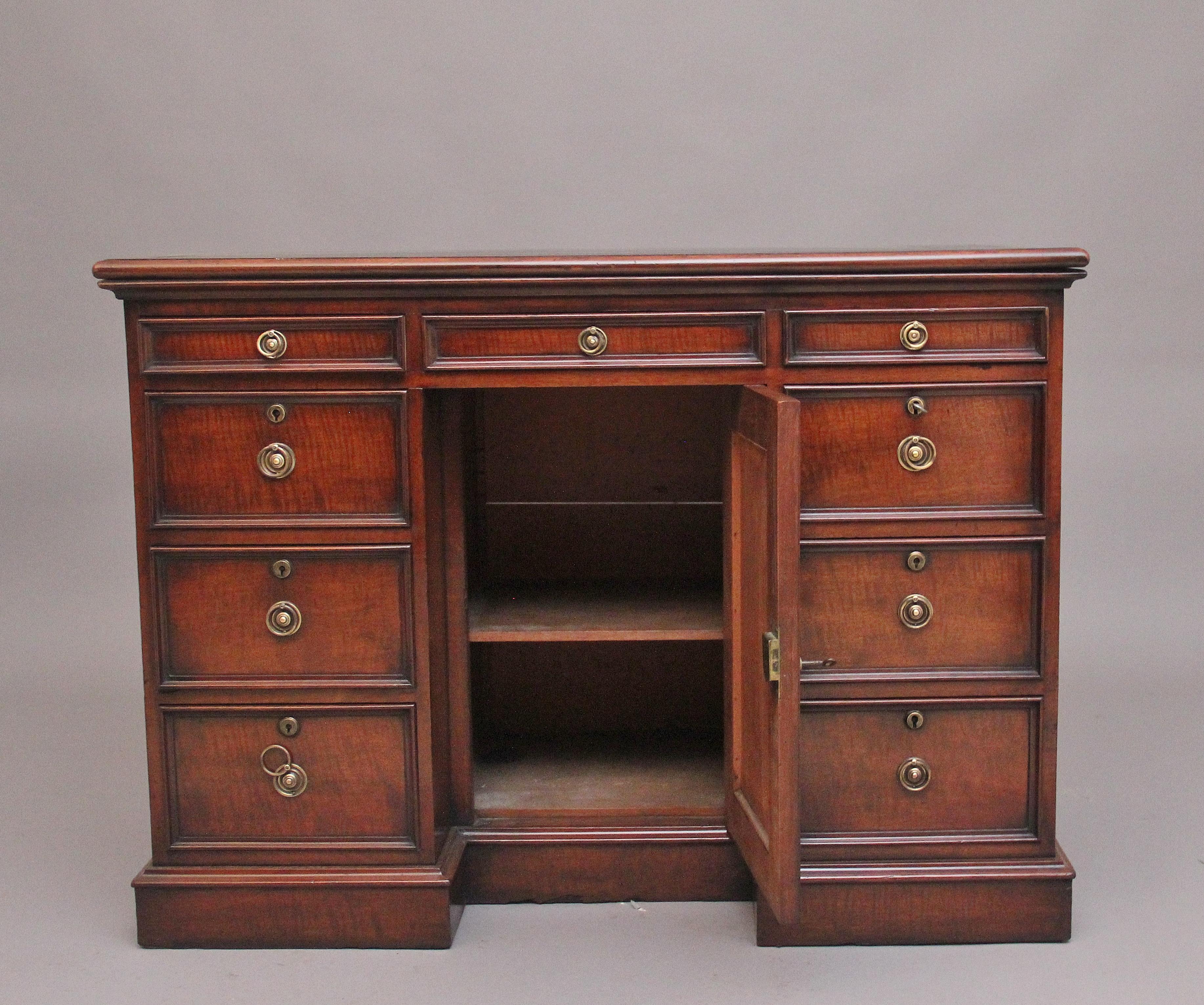 Scrivania a ginocchio in mogano dell'inizio del XIX secolo, con piano rettangolare con bordo sagomato e superficie di scrittura in pelle nera decorata con lavorazioni cieche e dorate, nove cassetti graduati rivestiti in mogano con maniglie originali