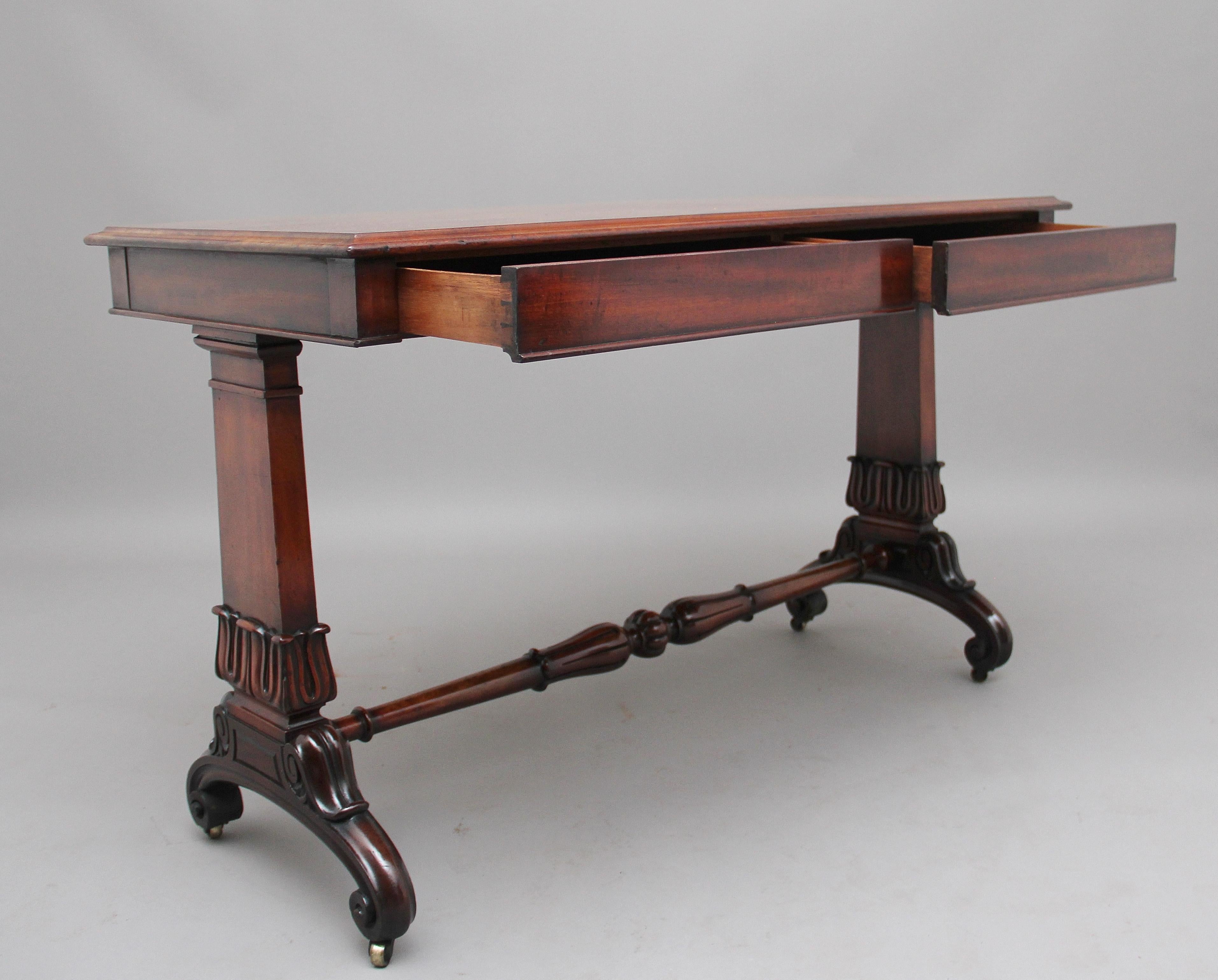 A lovely quality early 19th century mahogany library table, having a wonderfully figured solid top with a thumb moulded edge with two oak lined frieze drawers below, supported on two end supports with carved tulip decoration united with a turned and