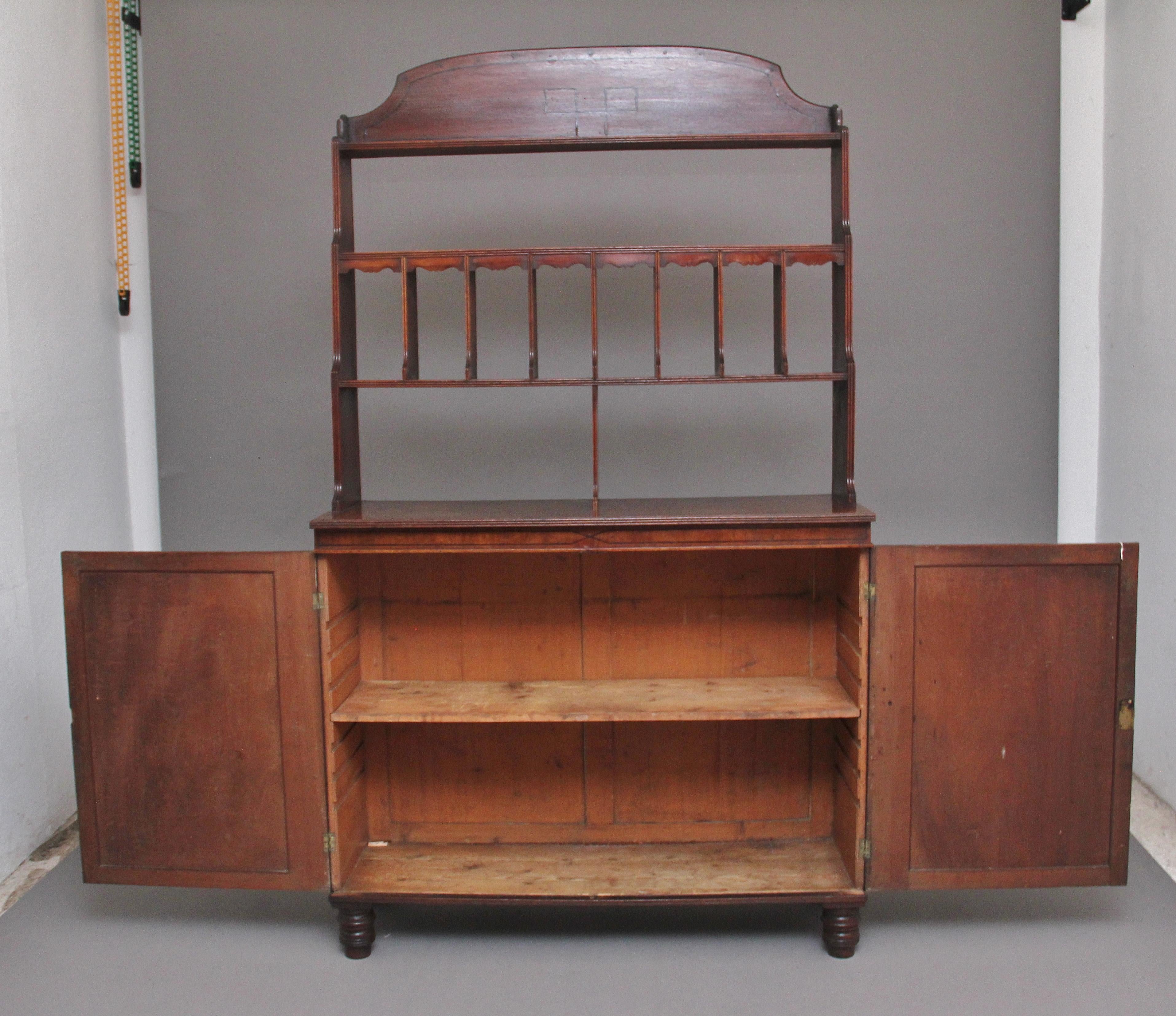 19th Century mahogany cabinet / bookcase, the open top section consisting of a decorative shaped and inlaid cornice and eight shelved compartments below with each compartment having a shaped top, the top section as well as the cabinet itself having