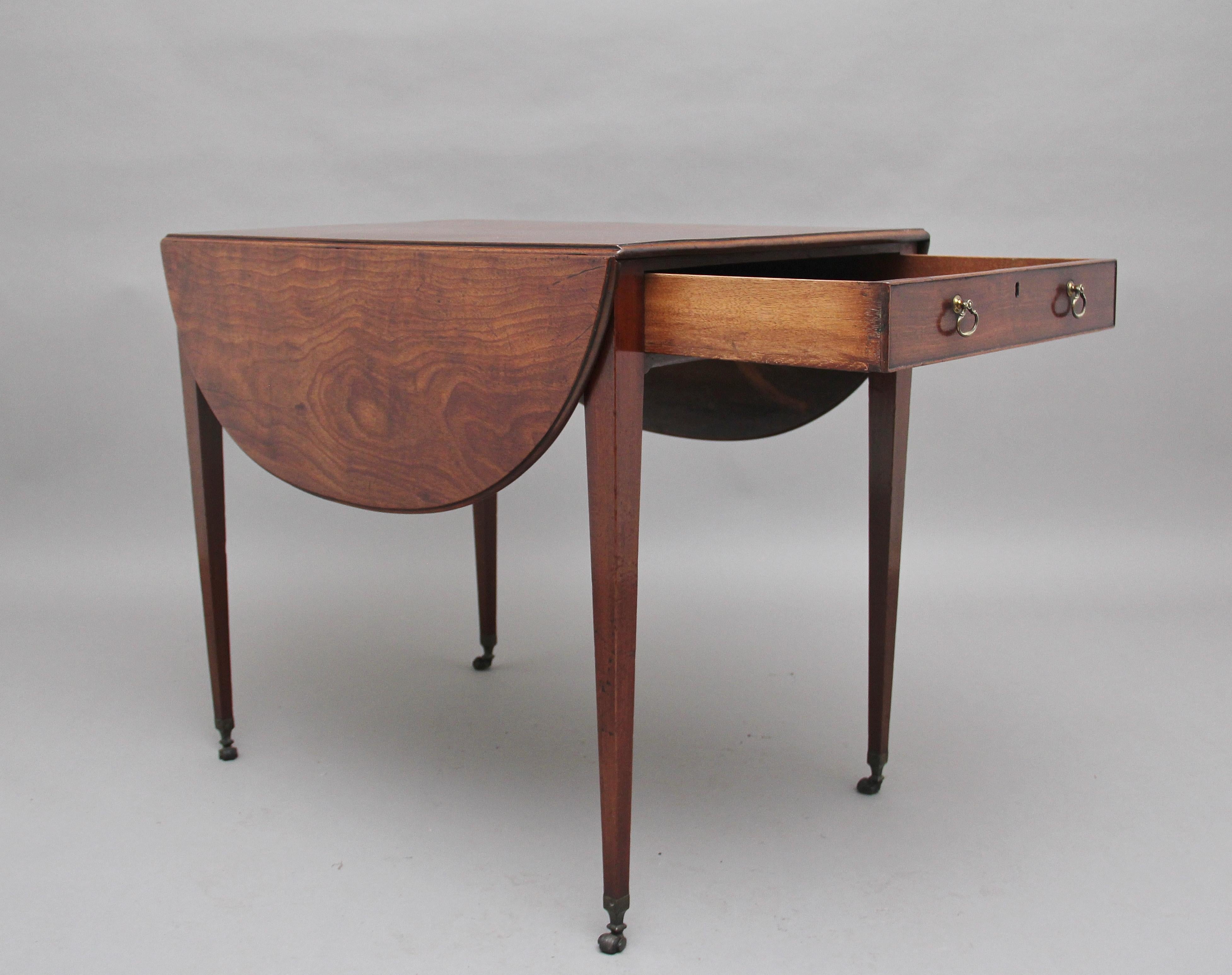 Une fabuleuse table ovale Pembroke en acajou du début du 19ème siècle, avec un magnifique plateau massif figuré avec un bord mouluré, un seul tiroir doublé en chêne à une extrémité avec des poignées en laiton, l'autre extrémité ayant un faux tiroir,