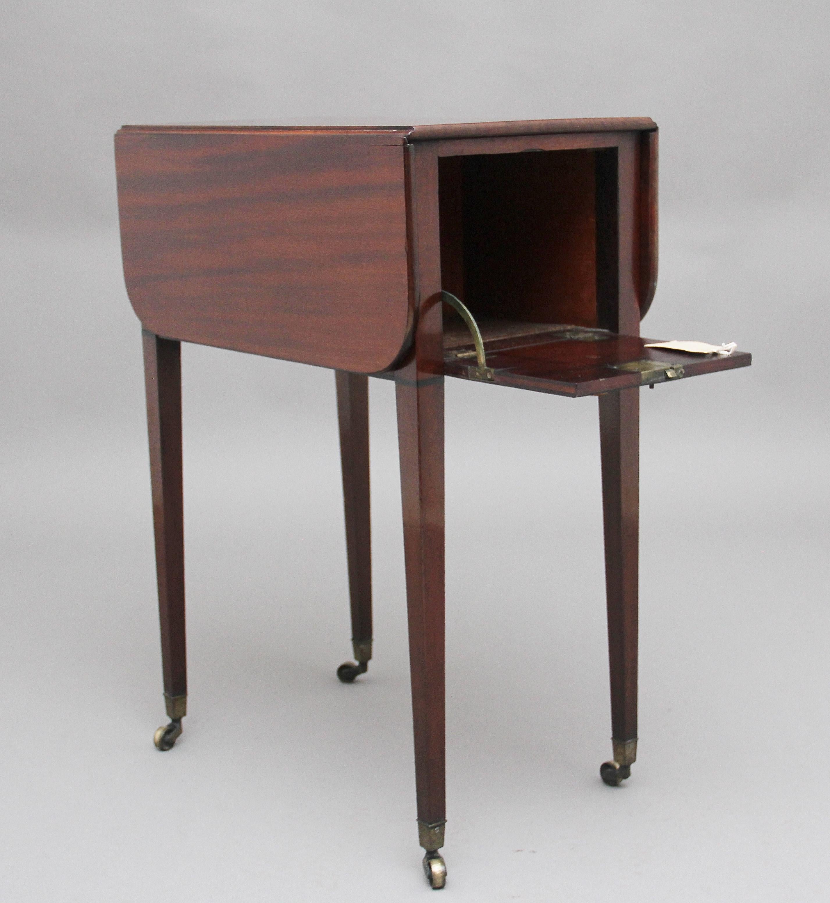 Early 19th century mahogany Pembroke table of nice proportions, the rounded edge drop leaf top above a hinged flap that drops down to reveal a compartment, this is the same on both ends of the table, supported on square tapering legs terminating on