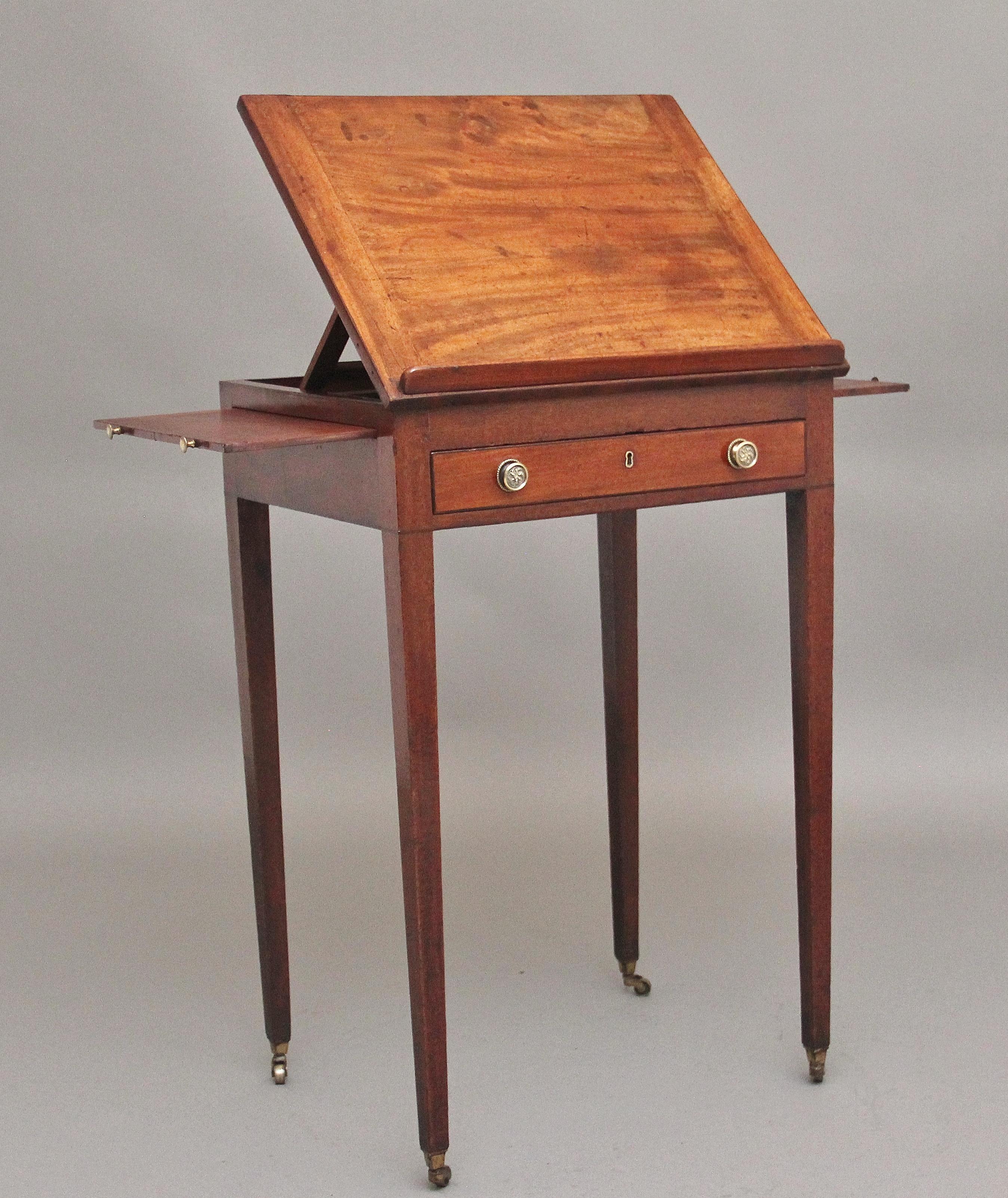 Early 19th Century mahogany reading / side table, having a lift up adjustable reading slope, pull out candle slides to each side, the front of the table is a single drawer with a fitted interior, having the original brass turned and engraved