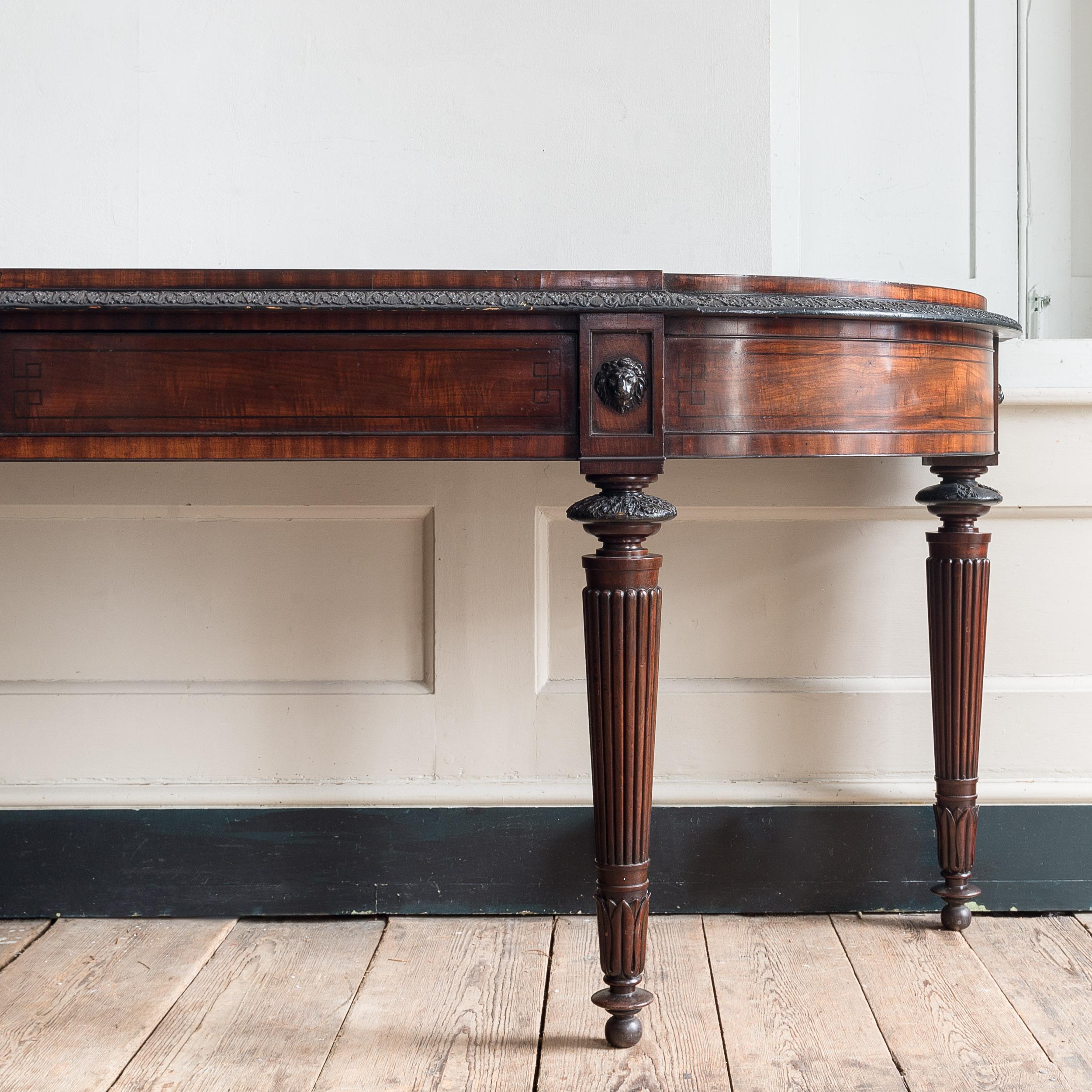 An early nineteenth century mahogany serving table, in the manner of George Oakley, with well figured d-shaped top, the single-step and ovolo moulded lip embellished with ebonised acanthus moulding, the frieze with ebonised line inlay in the Grecian