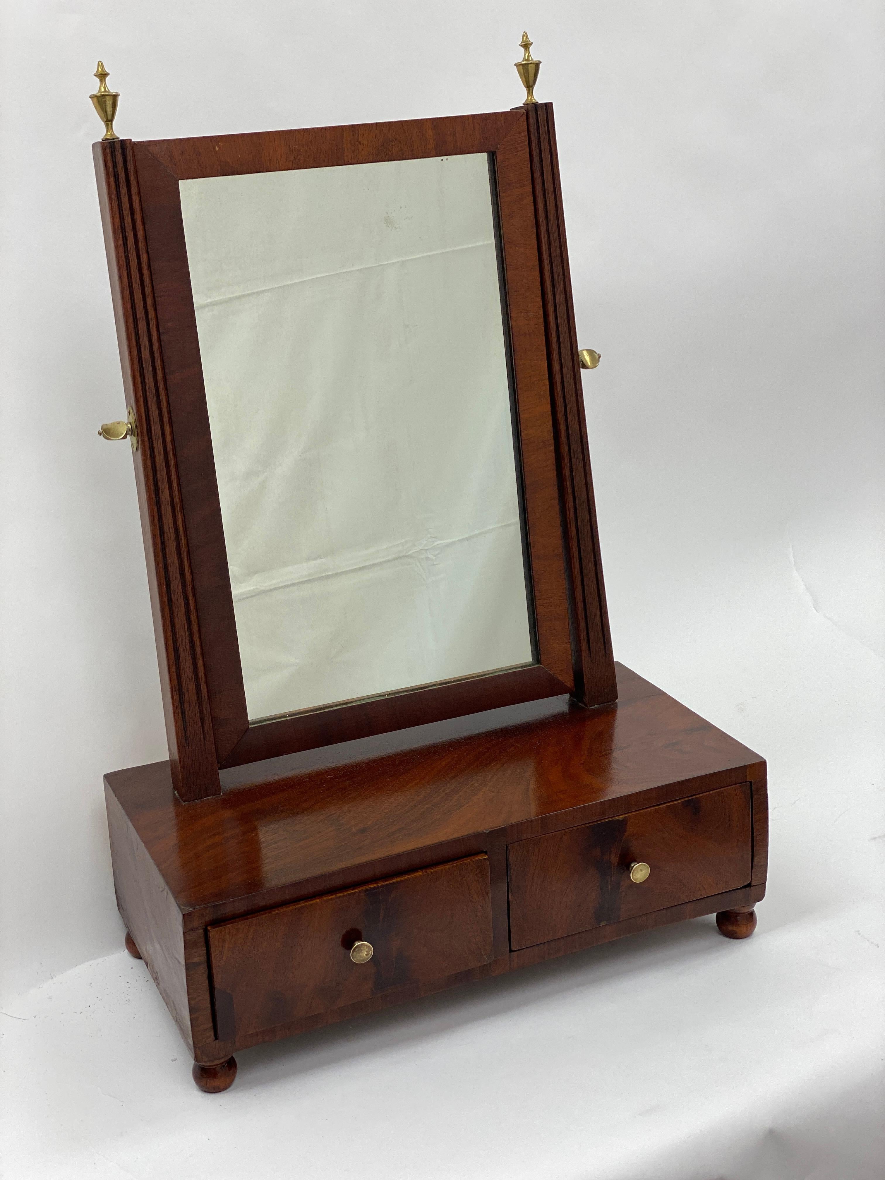 Early 19th century Mahogany shaving mirror, Circa 1810 
Two drawer box veneered in flamed Mahogany, Original brass hardware and original mirror. 
Simple & Elegant timeless design


Measures: 15