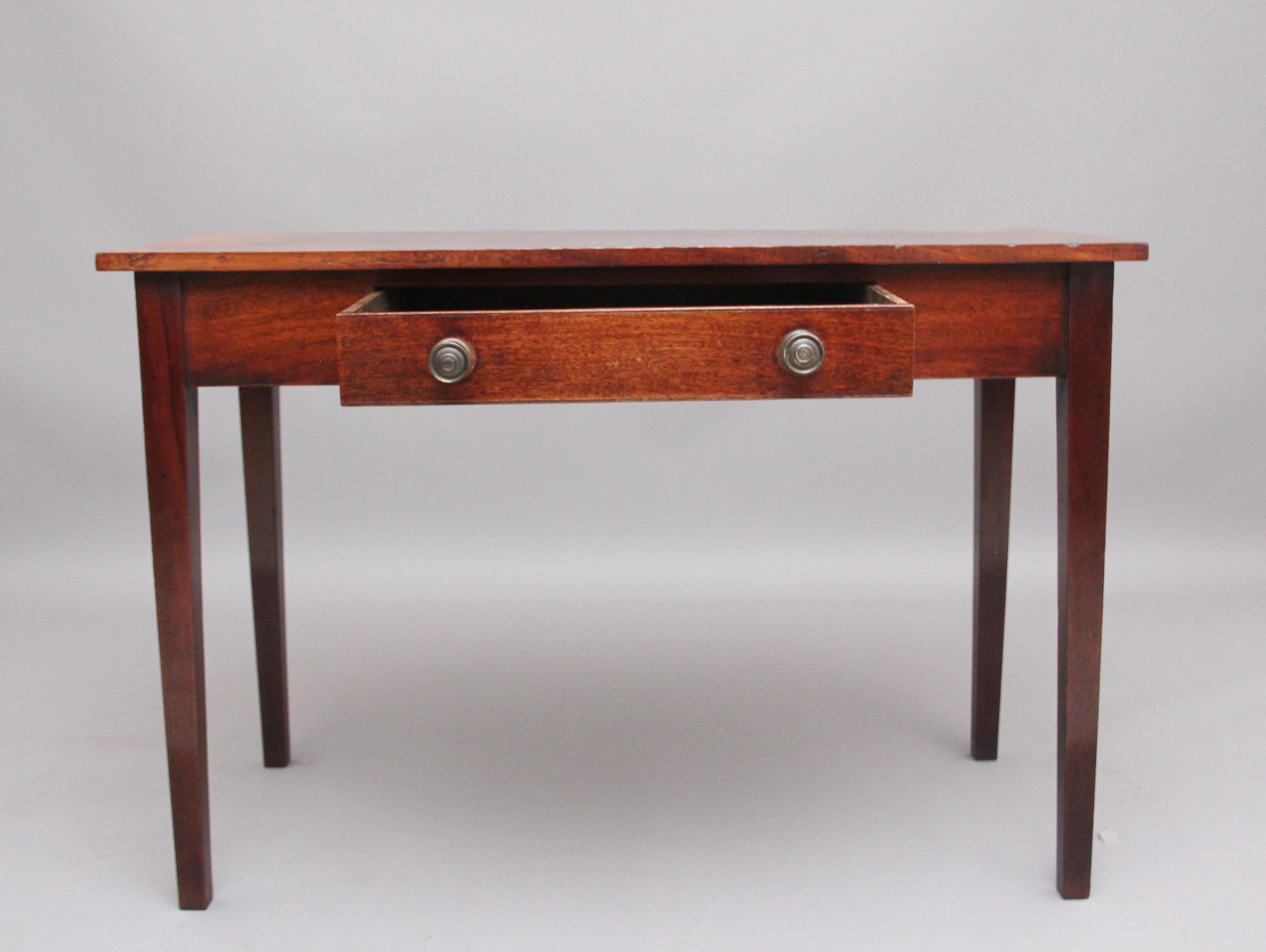 Early 19th century mahogany side table, having a lovely figured top above a single frieze drawer with original turned brass handles, standing on square tapering legs. Circa 1800.