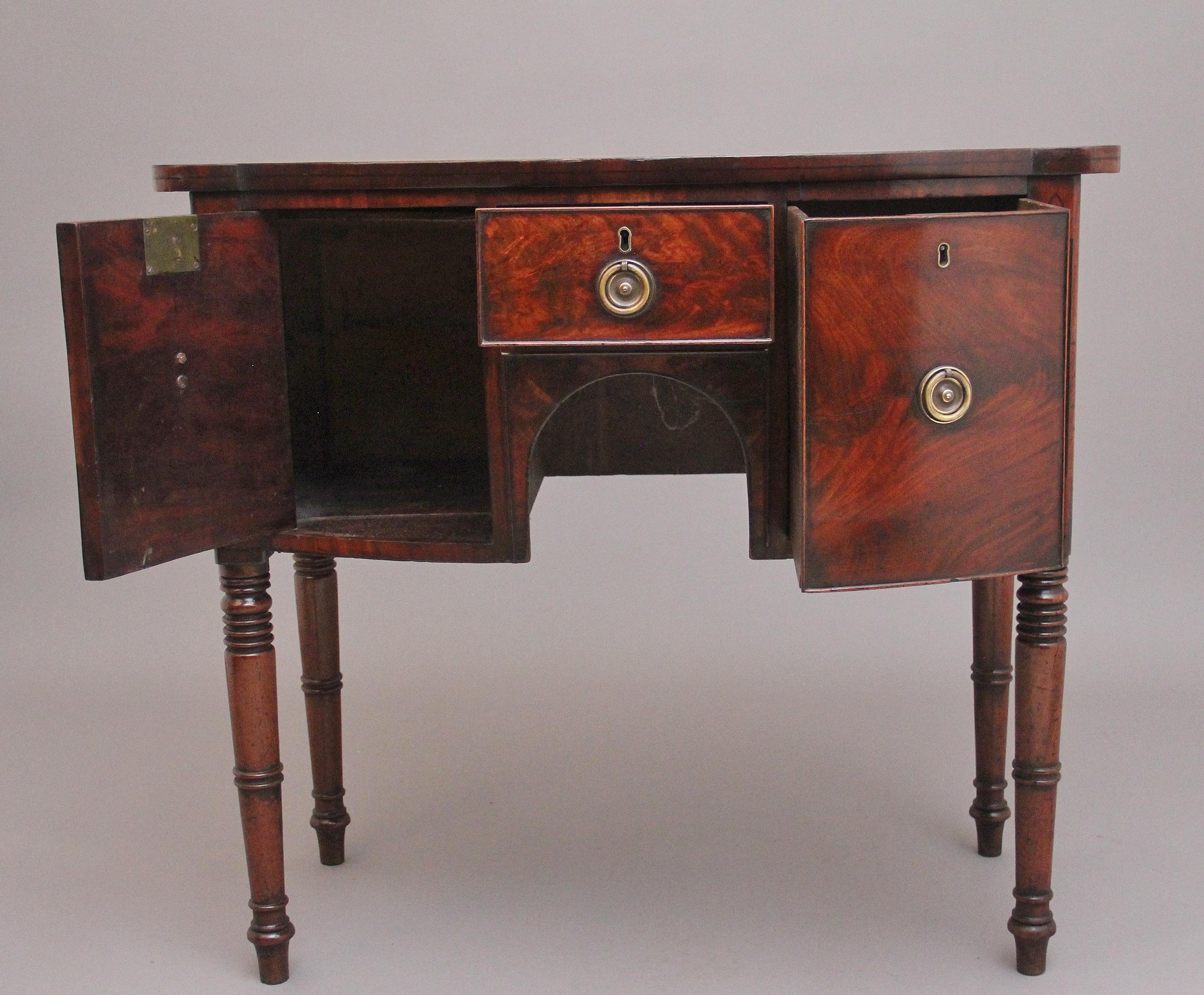 Early 19th Century mahogany bowfront sideboard of nice proportions , the well figured and shaped top above a central drawer flanked by a cupboard on one side and a deep drawer the other, all having brass engraved ring pull handles, having a