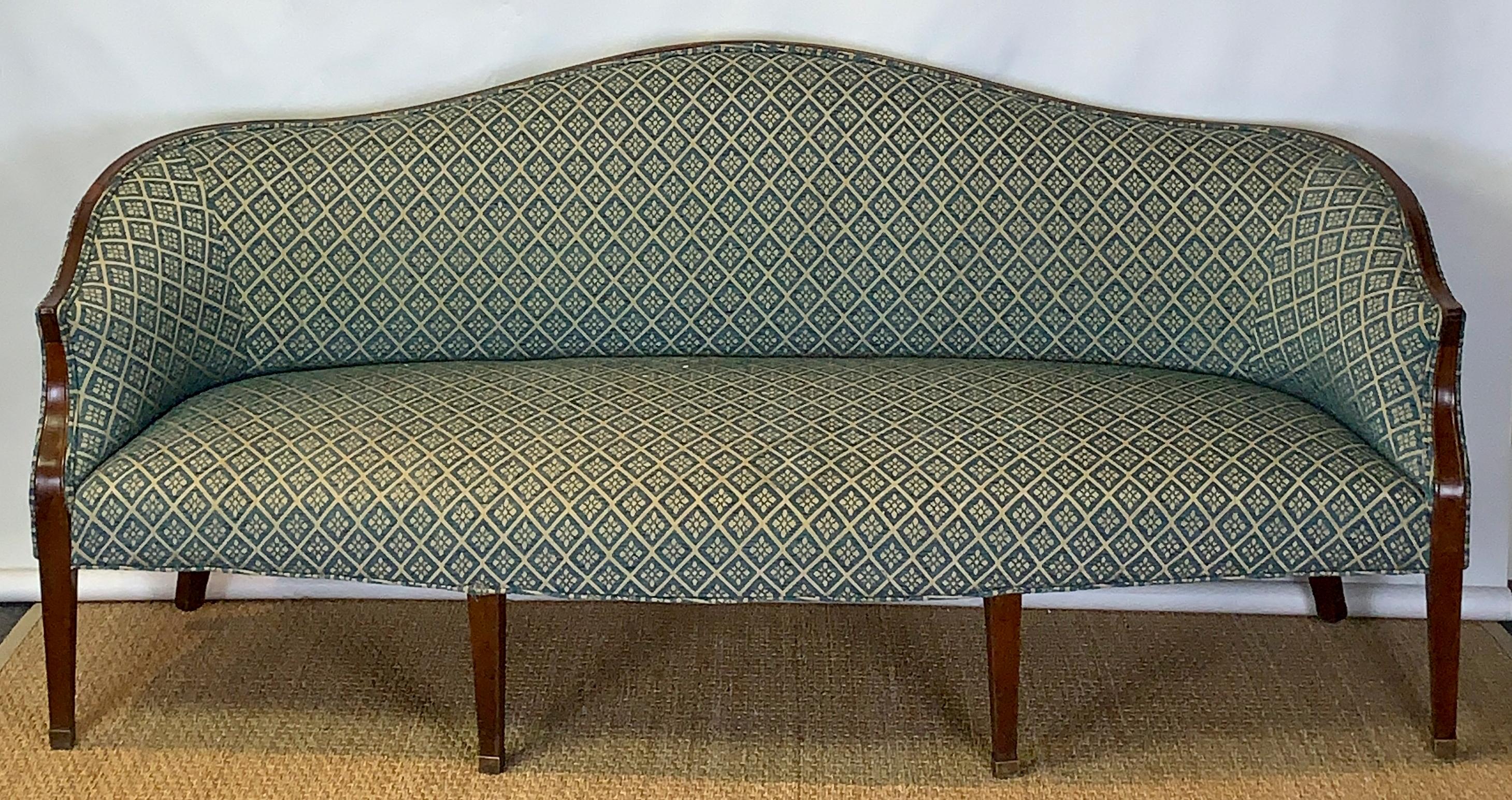 An early 19th C. American, possibly Baltimore, mahogany arched back sofa or settee upholstered in a blue tapestry style fabric supported on square tapering legs terminating in brass capped feet.