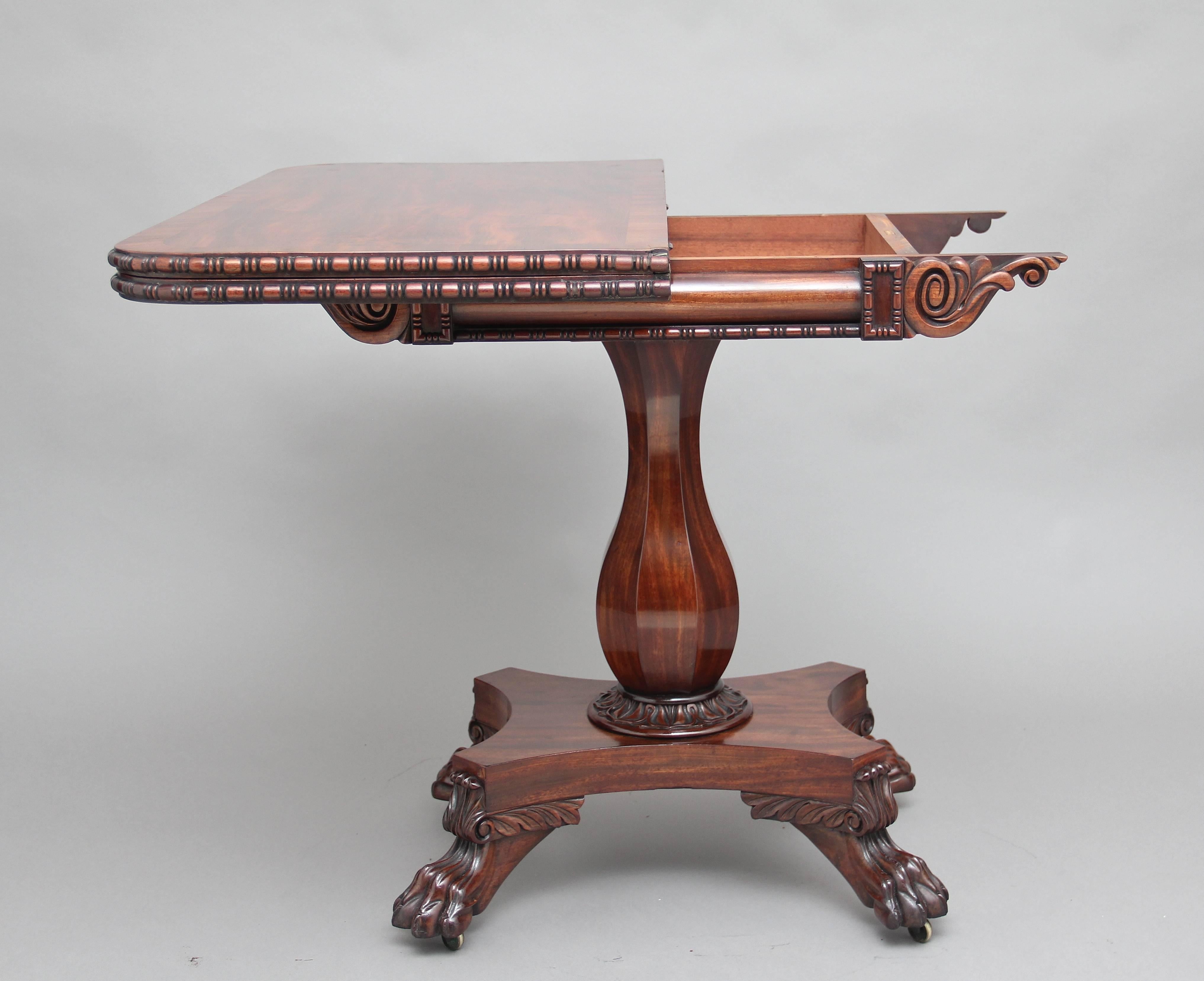 Early 19th century mahogany tea table, the fold over rounded rectangular crossbanded top with egg and dart moulding, with a nice carved frieze below with stylized floral carvings in the corners, supported on an elegant shaped column standing on a