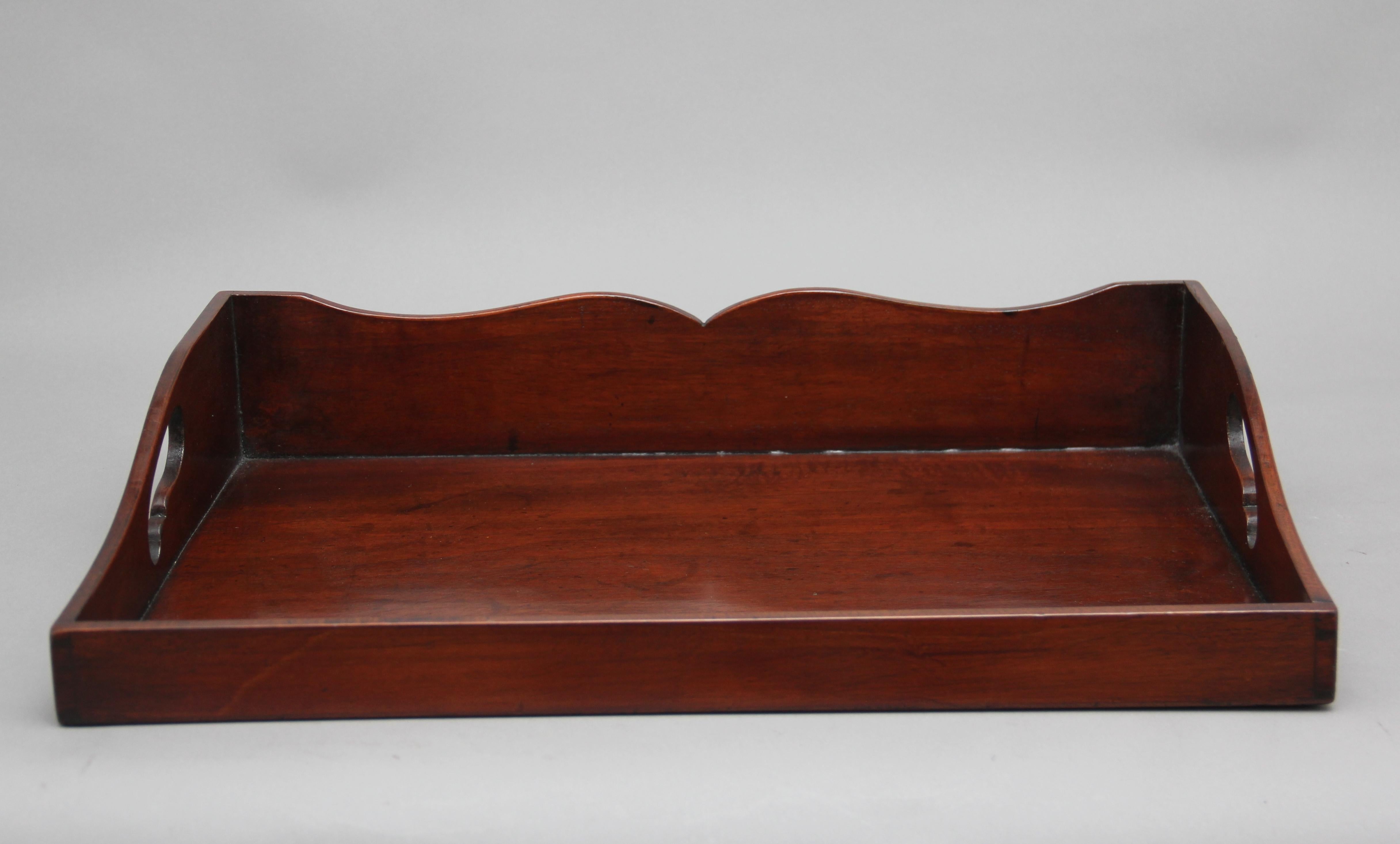 Early 19th century mahogany tray of rectangular form, surround gallery three quarters raised and with two fret cut carrying handles, circa 1830.
 