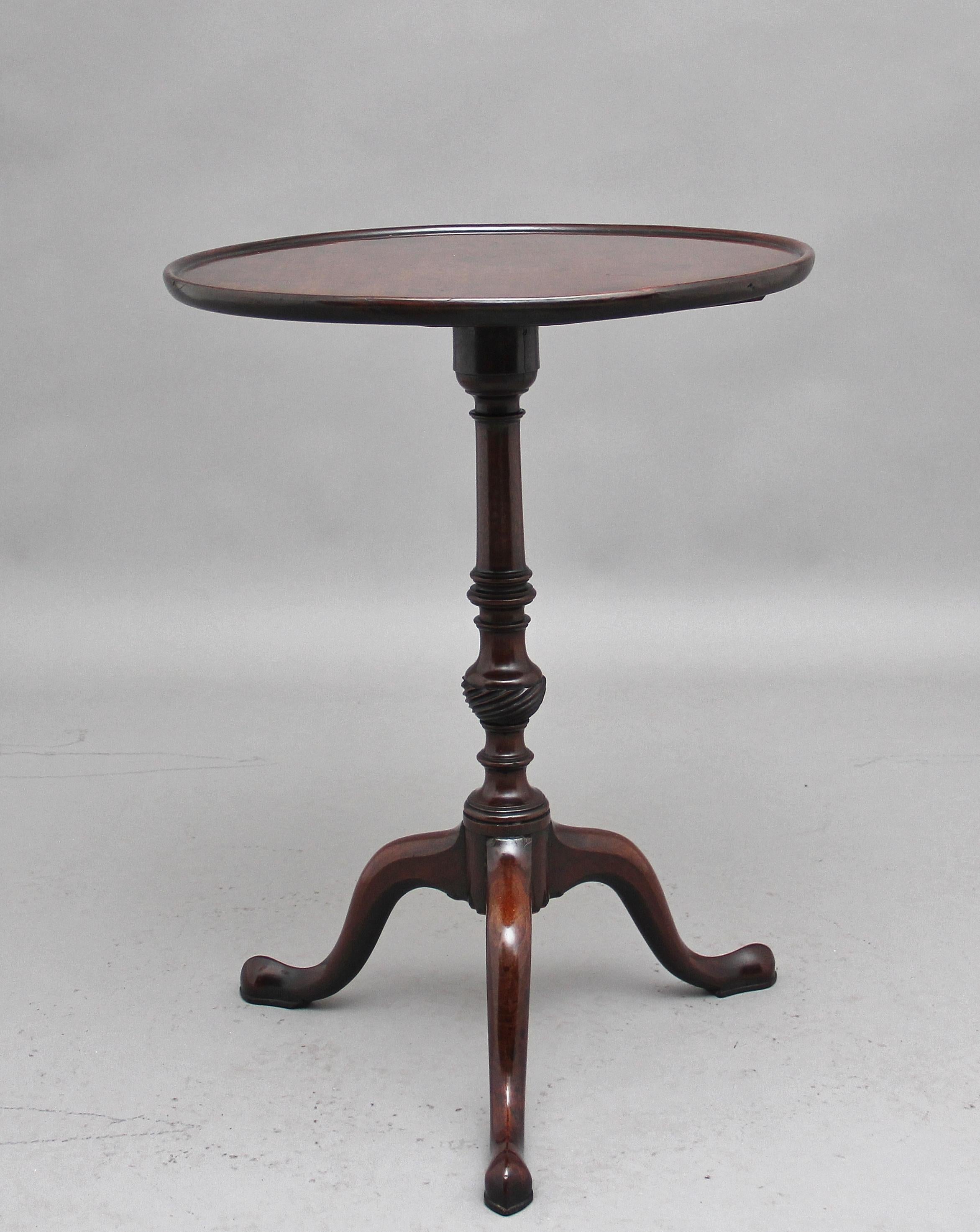Early 19th century mahogany wine table with a circular dished top supported on a wonderfully turned and carved column terminating with three slender shaped legs, circa 1820.
 