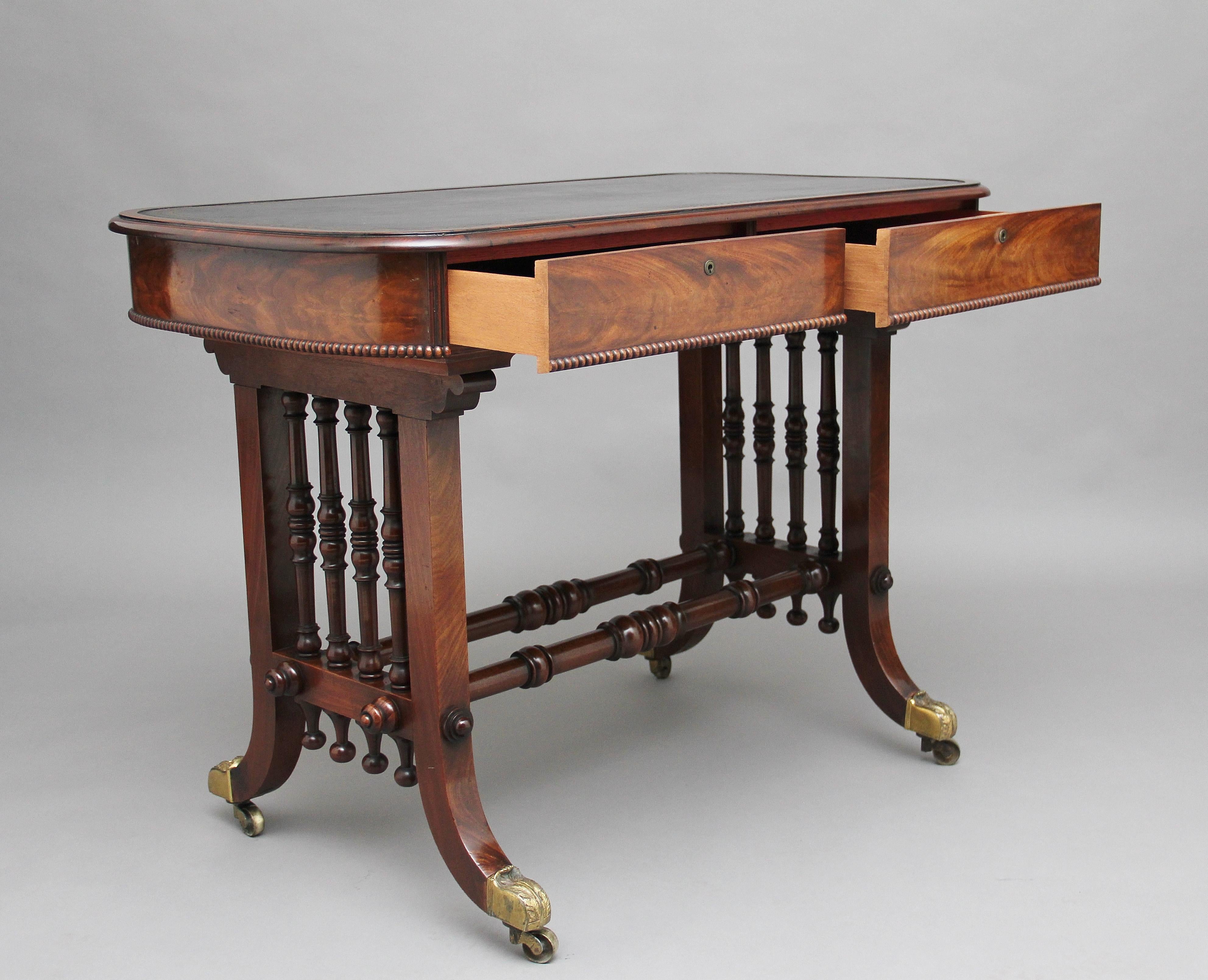Early 19th century mahogany writing table, the oval shaped top having a moulded edge, green leather writing surface decorated with blind and gold tooling, two mahogany lined frieze drawers below with carved bead decoration running along the bottom