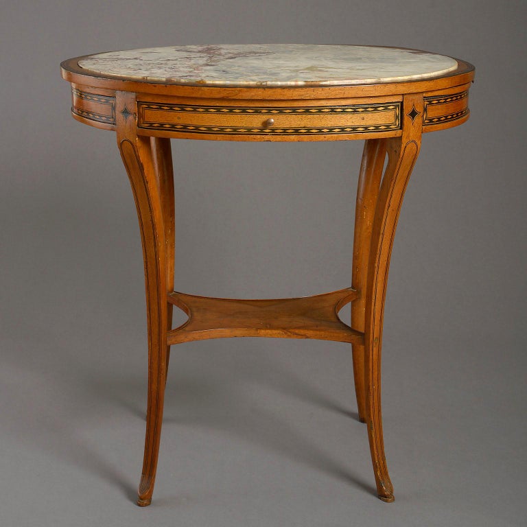 An early 19th century marble-topped centre table, the Breche Violette marble inset top above a frieze fitted with an arrangement of opposing drawers and slides above shaped sabre legs united by an under tier all in walnut inlaid with boxwood and