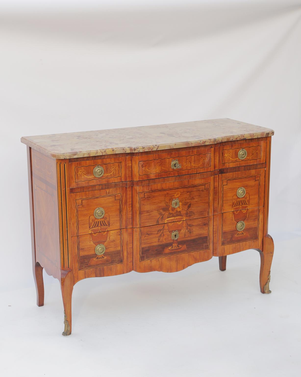 Commode, having a top of Breche d'Alep marble, on conforming case, inlaid decoration of festooning and a trio of neoclassical urns; round pulls and escutcheons of gilt bronze, the trio of stacked drawers flanked by rounded, fluted stiles, raised on