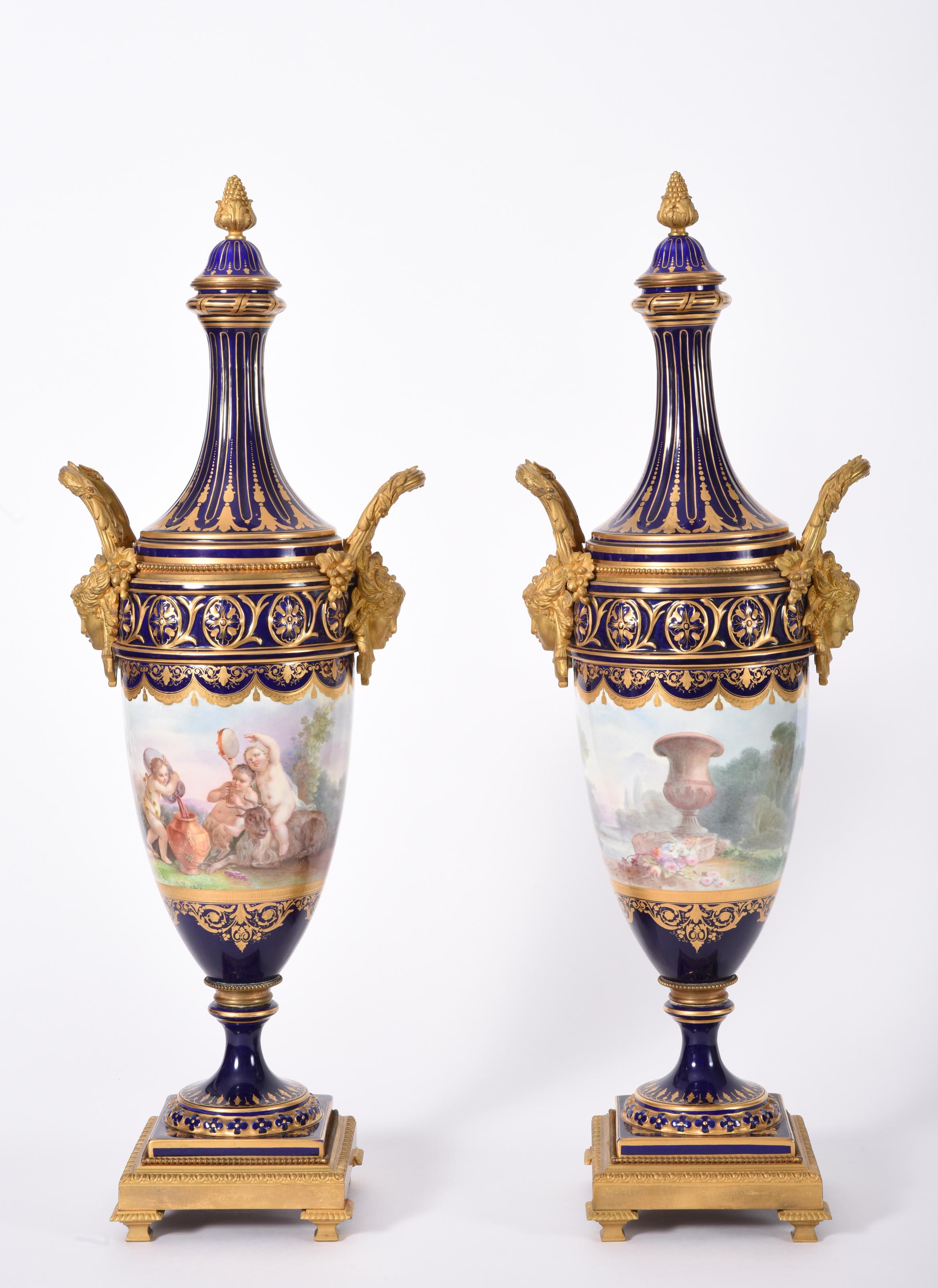 Early 19th century matching pair of Sèvres style gilt bronze mounted porcelain centerpiece urns. These superbly hand painted / decorated pieces are just exquisite and in excellent antique condition with minor wear consistent to age and use. Each urn