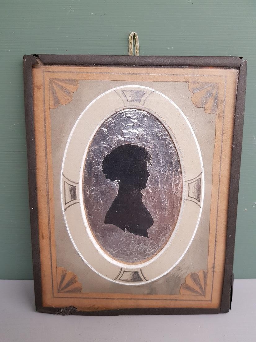 Antique miniature silhouette with image of a lady on a silver / aluminum-like background and a passe-partout colored in pencil, on the back is the description of the lady, which is furthermore in a good condition for his age. Originating from the