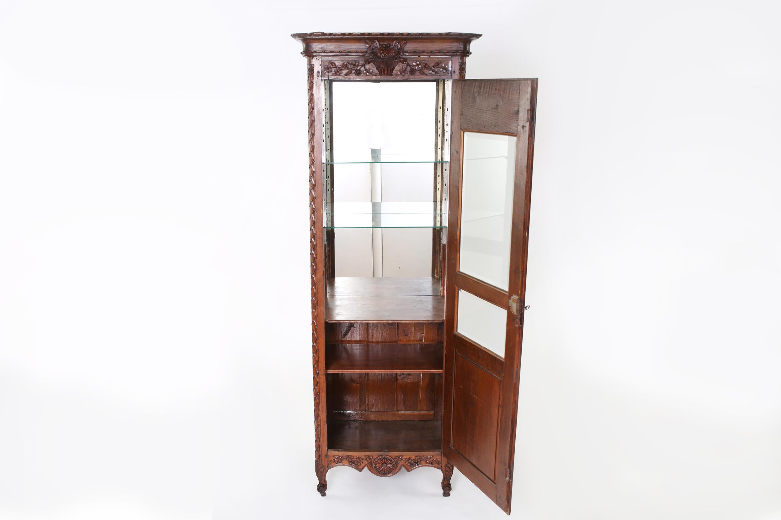 Early 19th century French Renaissance Revival hand carved walnut display cabinet with exterior design details. The display cabinet is in good antique condition with age / use appropriate wear. Crown molding top completely removable for easy access