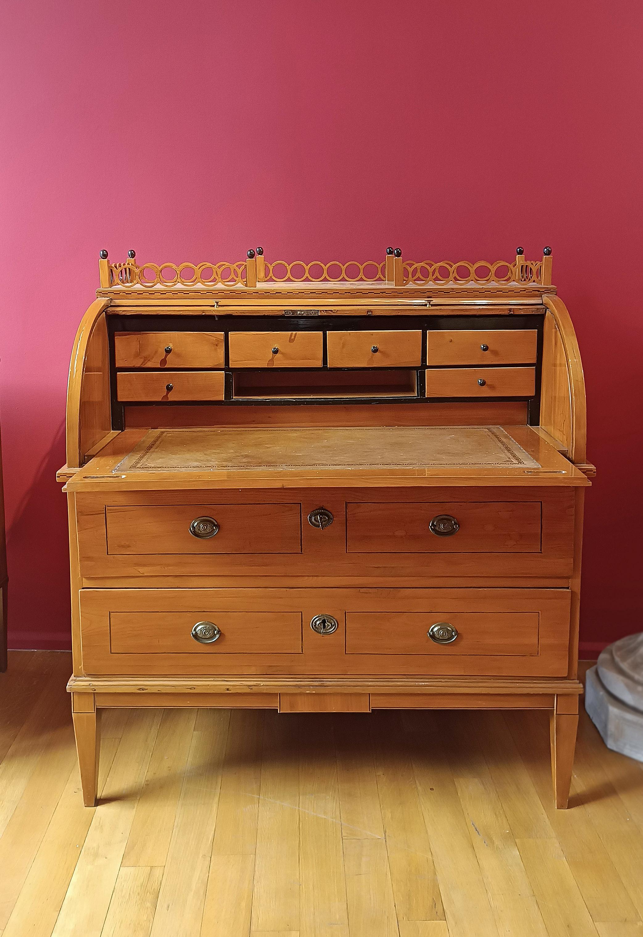 Elegant roller drop-down table in solid hand-carved cherry, embellished with a maple wood terrace. The drop-down table recalls an English style, with truncated pyramid legs and two ergonomic drawers ideal for storing objects. Its peculiarity lies in