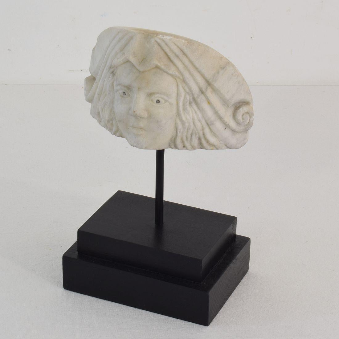 Beautiful weathered neoclassical marble fragment representing a head.
Italy, circa 1800-1840. Weathered
Measurement here below includes the wooden base.