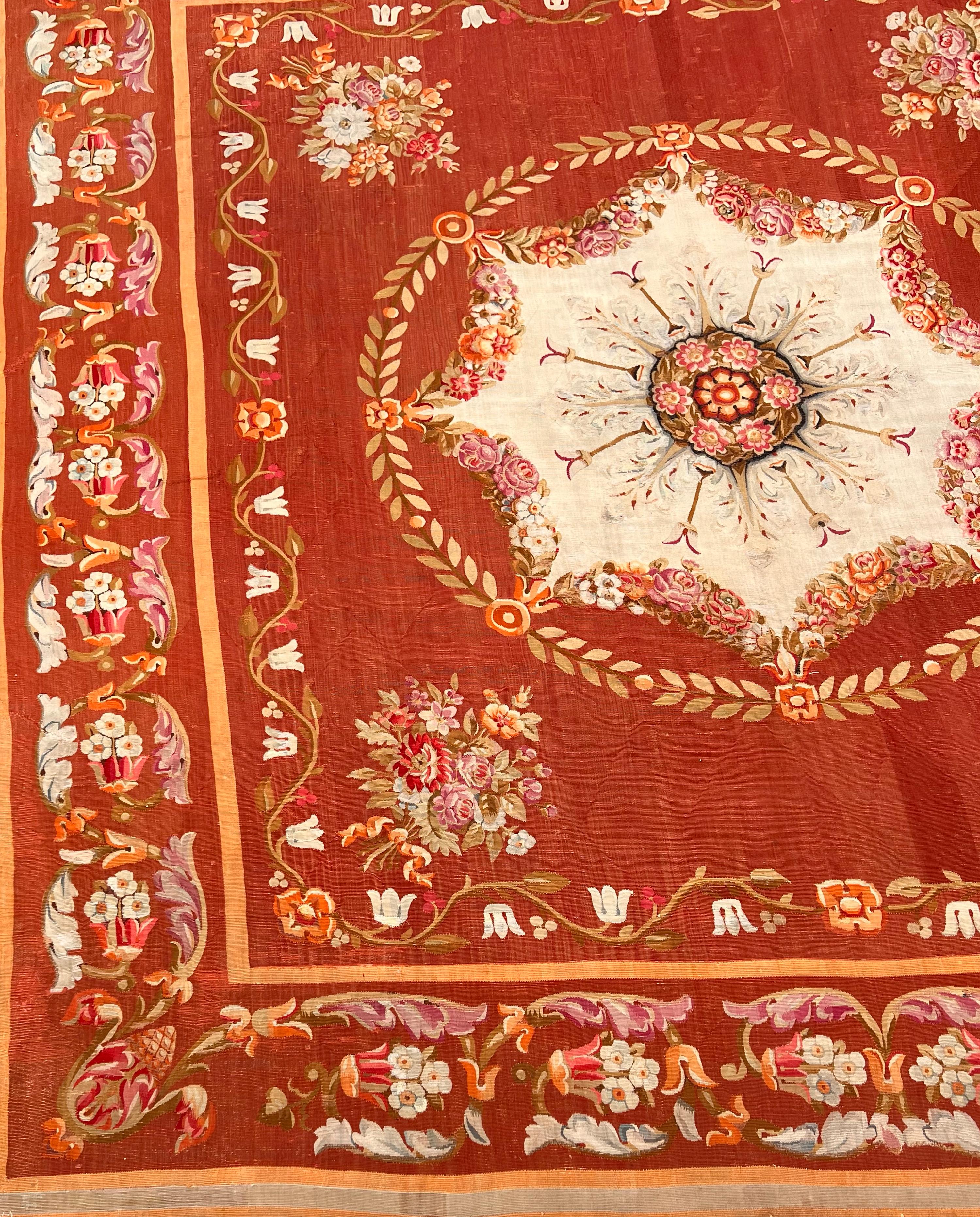 A remarkably well-preserved and richly colored Neoclassical period early 19th century carpet.  A burgundy and cinnamon field is bound by a melon border with floral and acanthus meander.  Bouquets in each corner surround an octagonal medallion with